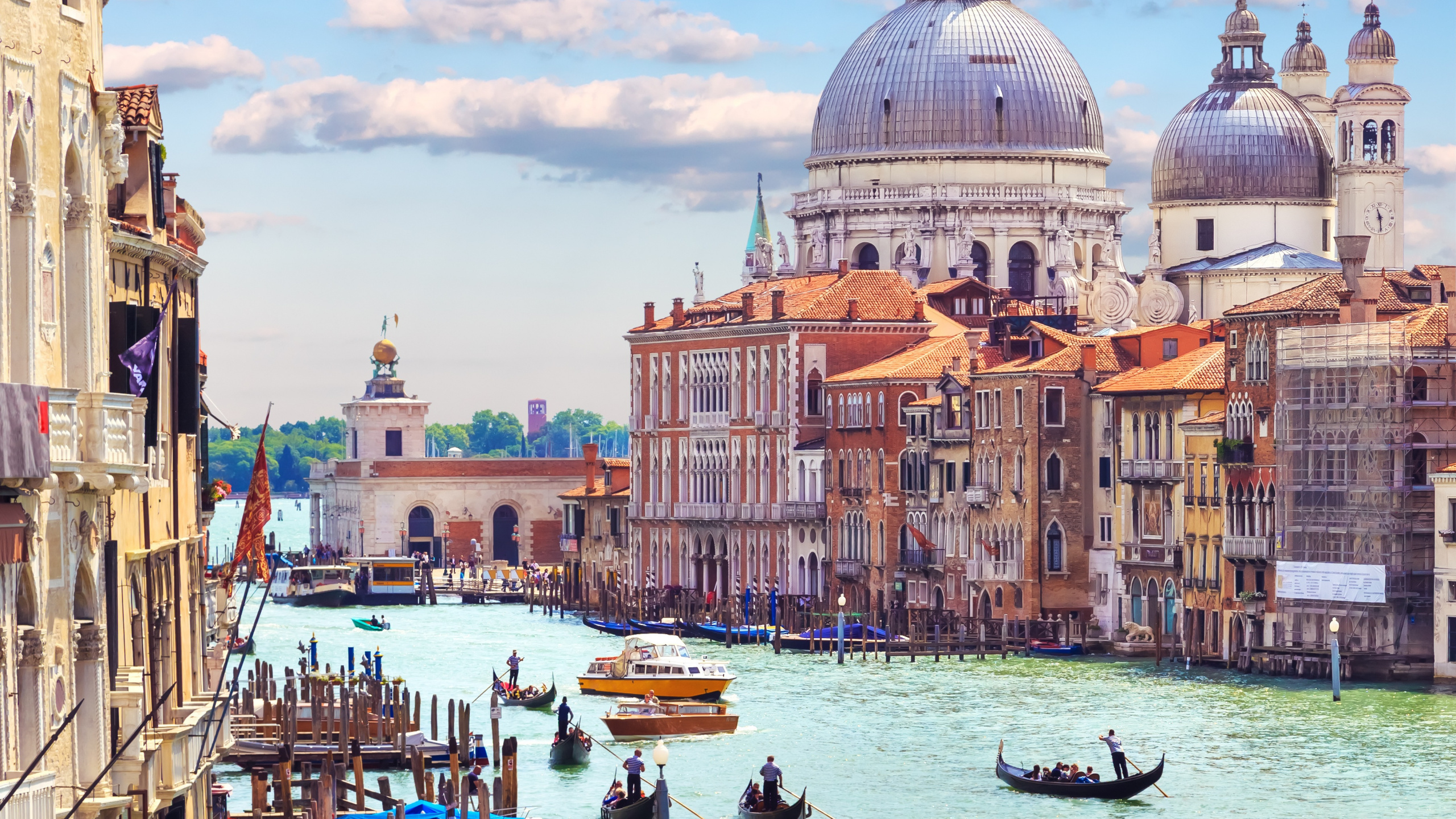 People Riding on Boat on Body of Water Near Brown Concrete Building During Daytime. Wallpaper in 2560x1440 Resolution