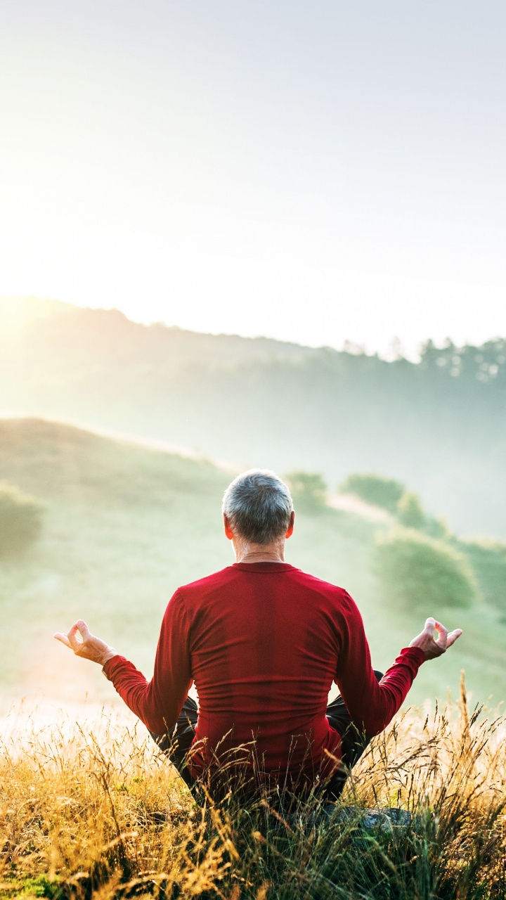 Man in Red and Black Striped Long Sleeve Shirt Sitting on Brown Grass Field During Daytime. Wallpaper in 720x1280 Resolution