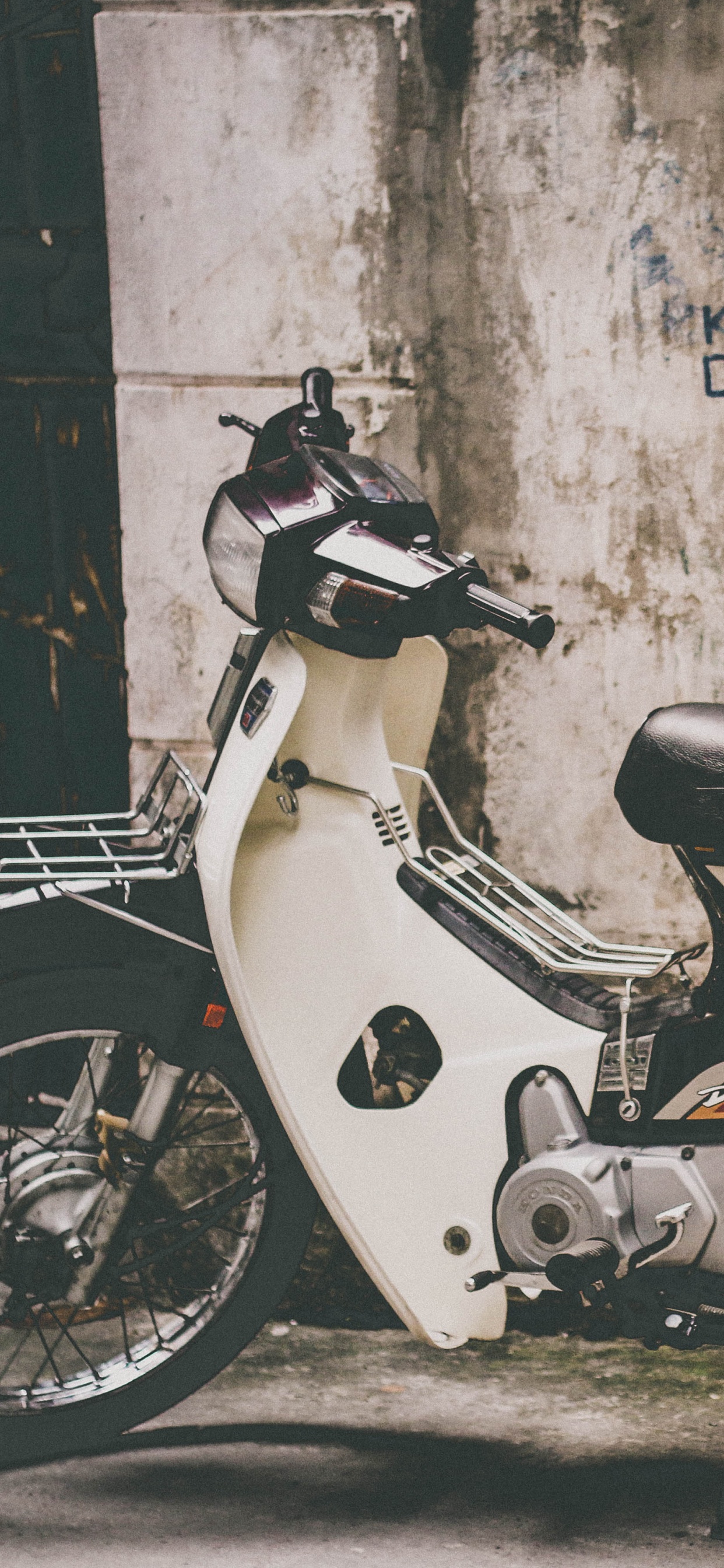 Motocicleta Desnuda Roja y Blanca Estacionada Junto a la Pared. Wallpaper in 1242x2688 Resolution