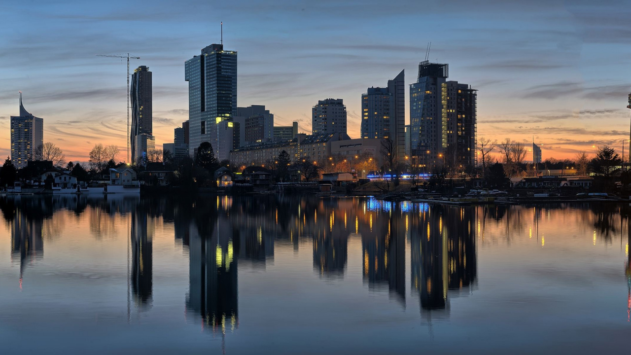 Skyline Der Stadt Über Gewässer Während Der Nacht. Wallpaper in 1280x720 Resolution