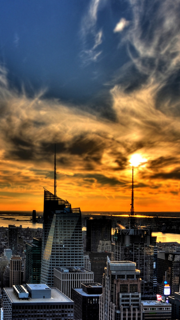 Stadt Mit Hochhäusern Unter Blauem Himmel Bei Sonnenuntergang. Wallpaper in 750x1334 Resolution