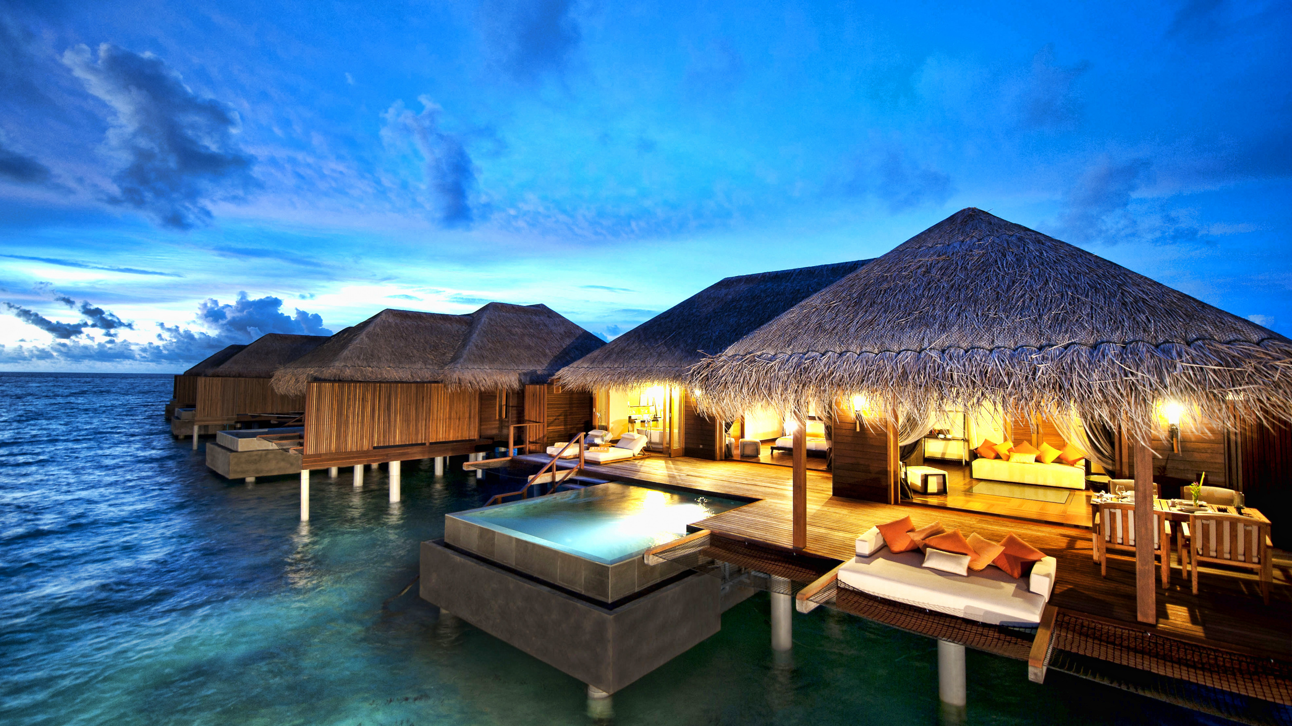 Brown Wooden Houses on Green Water Under Blue Sky During Daytime. Wallpaper in 2560x1440 Resolution