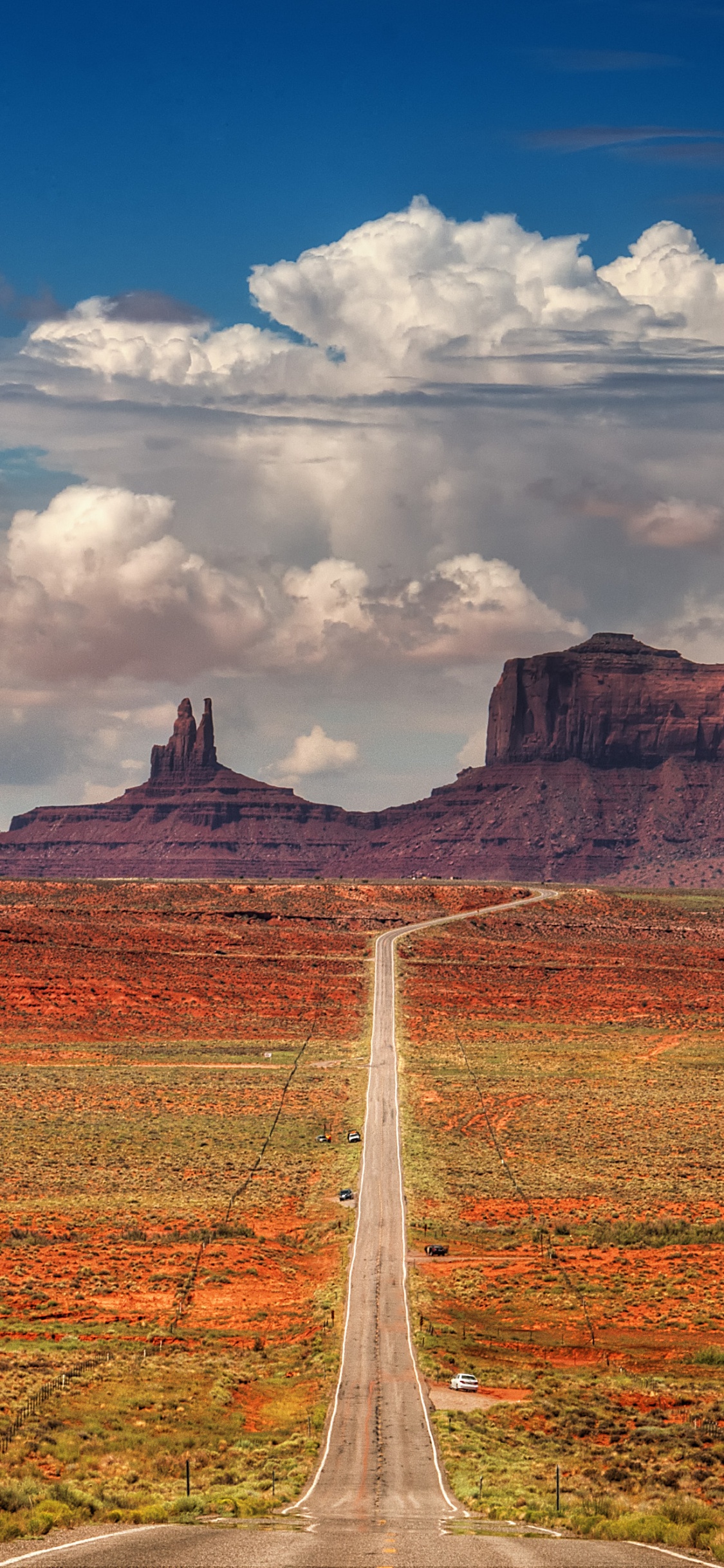 Brown and Green Grass Field Near Mountain Under White Clouds and Blue Sky During Daytime. Wallpaper in 1125x2436 Resolution