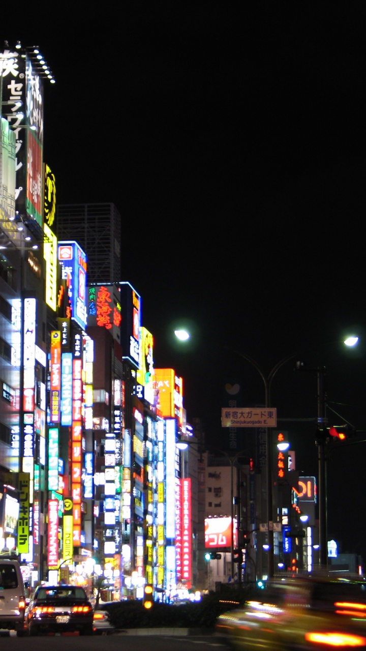 Cars on Road Between High Rise Buildings During Night Time. Wallpaper in 720x1280 Resolution