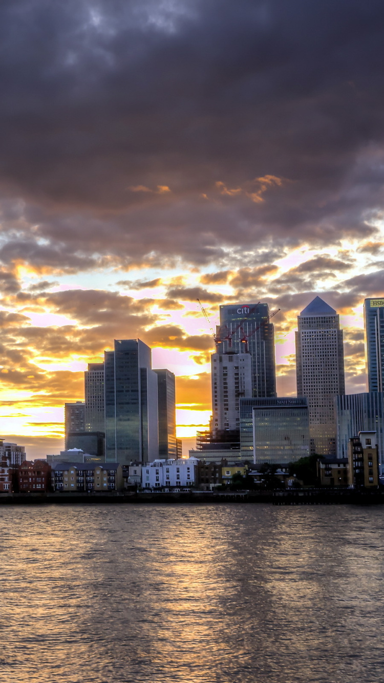 Horizonte de la Ciudad a Través Del Cuerpo de Agua Durante la Puesta de Sol. Wallpaper in 750x1334 Resolution