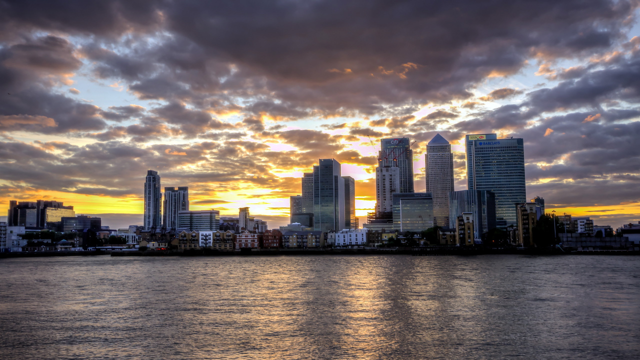 Skyline Der Stadt Über Gewässer Bei Sonnenuntergang. Wallpaper in 1280x720 Resolution