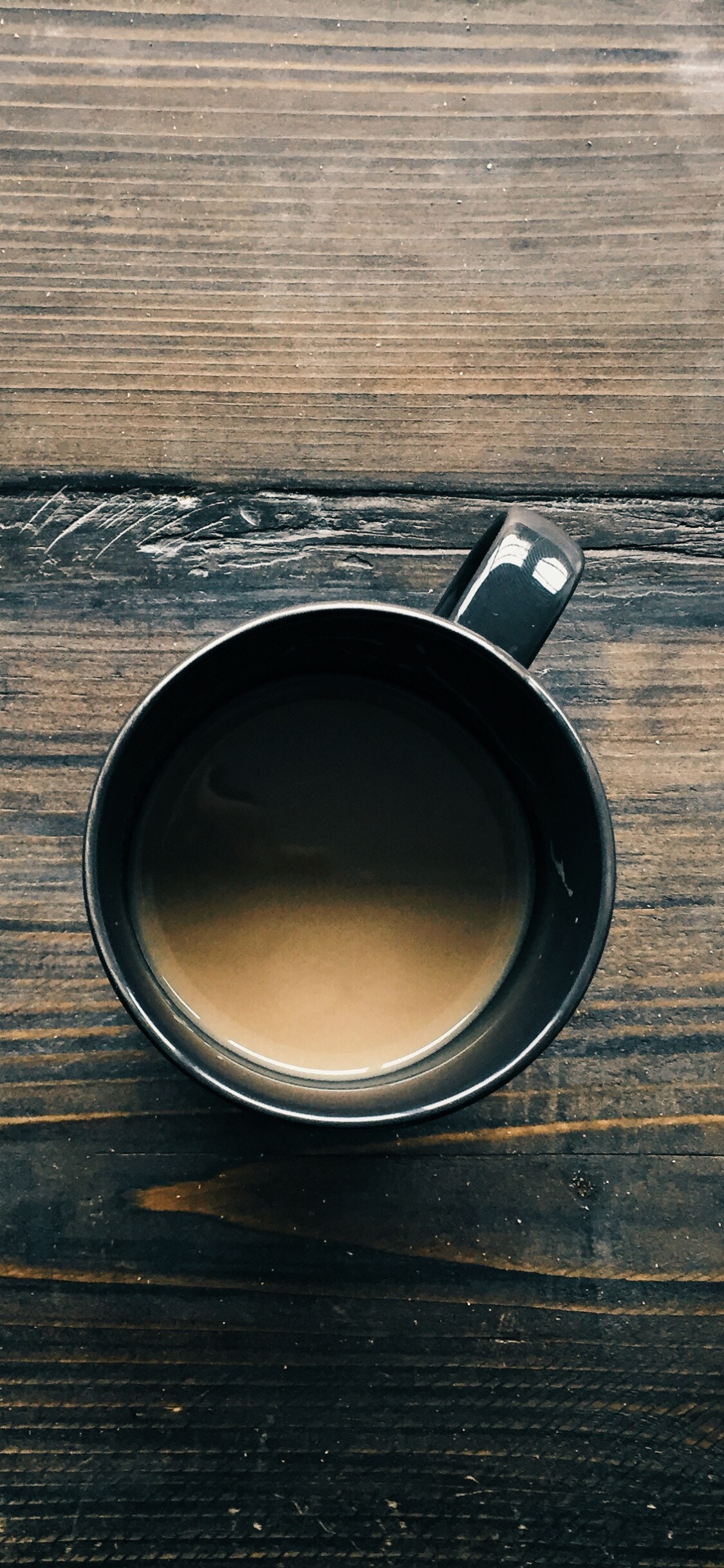 Black Ceramic Mug on Brown Wooden Table. Wallpaper in 1125x2436 Resolution