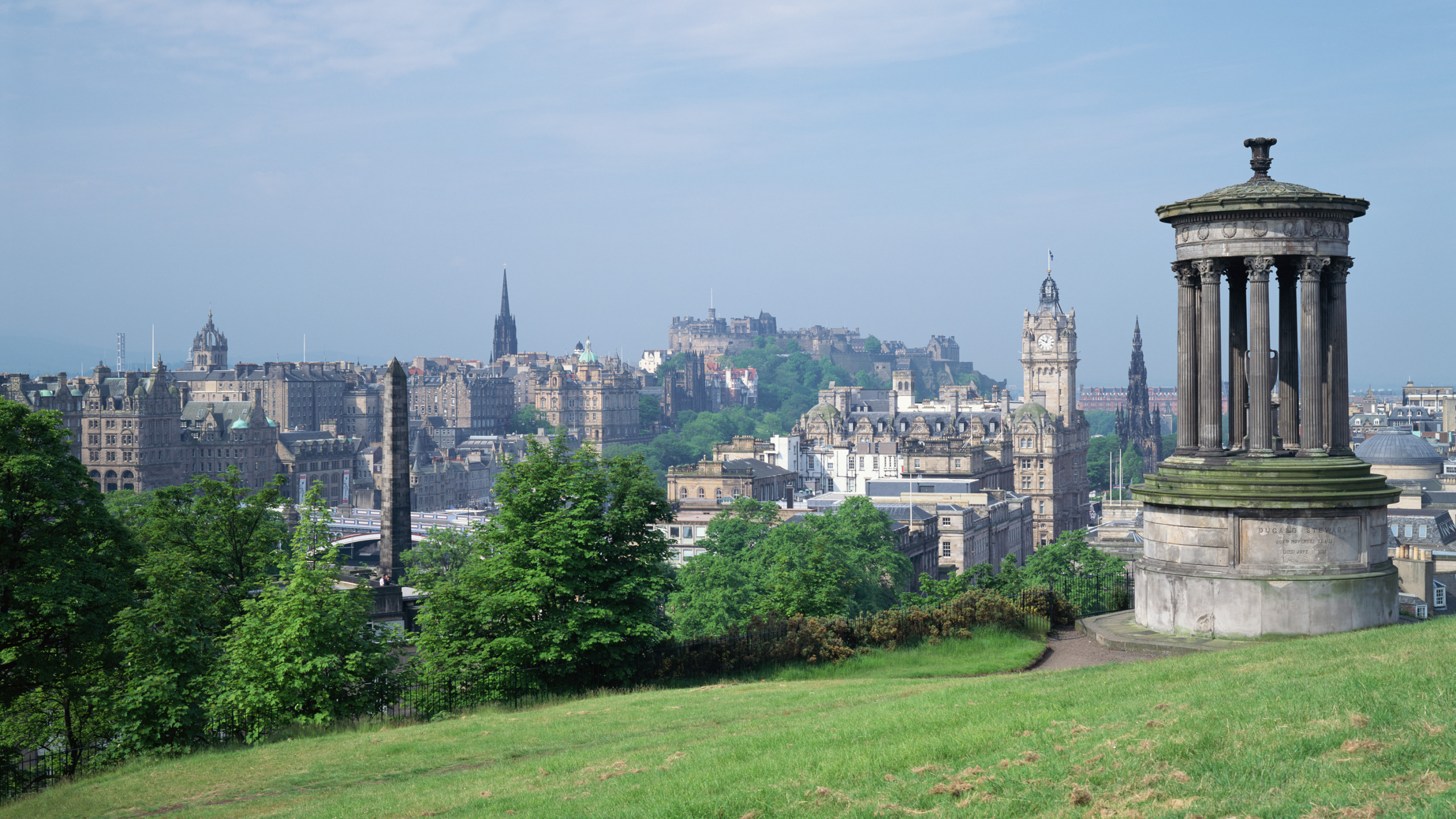 Green Grass Field Near City Buildings During Daytime. Wallpaper in 2560x1440 Resolution