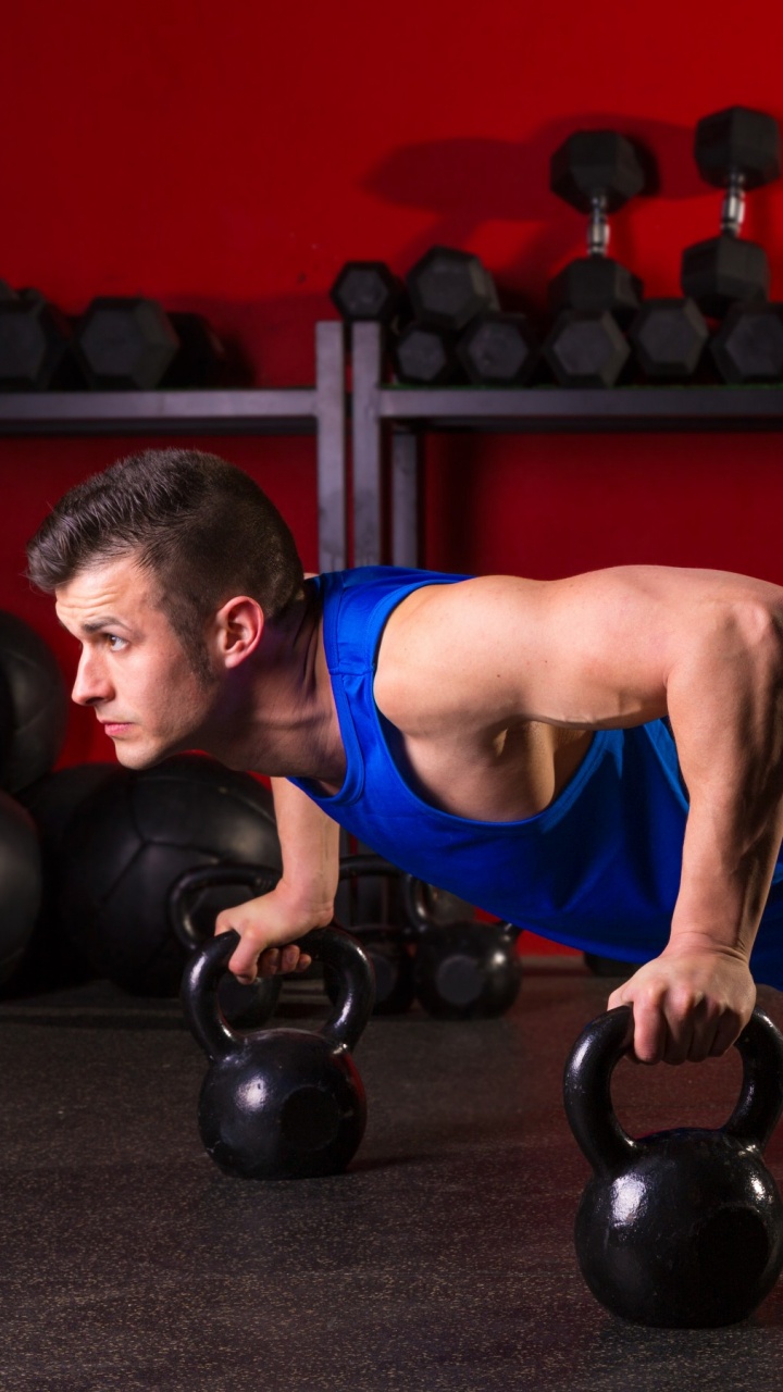 Mann in Blauem Tanktop Und Schwarzen Shorts Mit Schwarzer Kettlebell. Wallpaper in 720x1280 Resolution