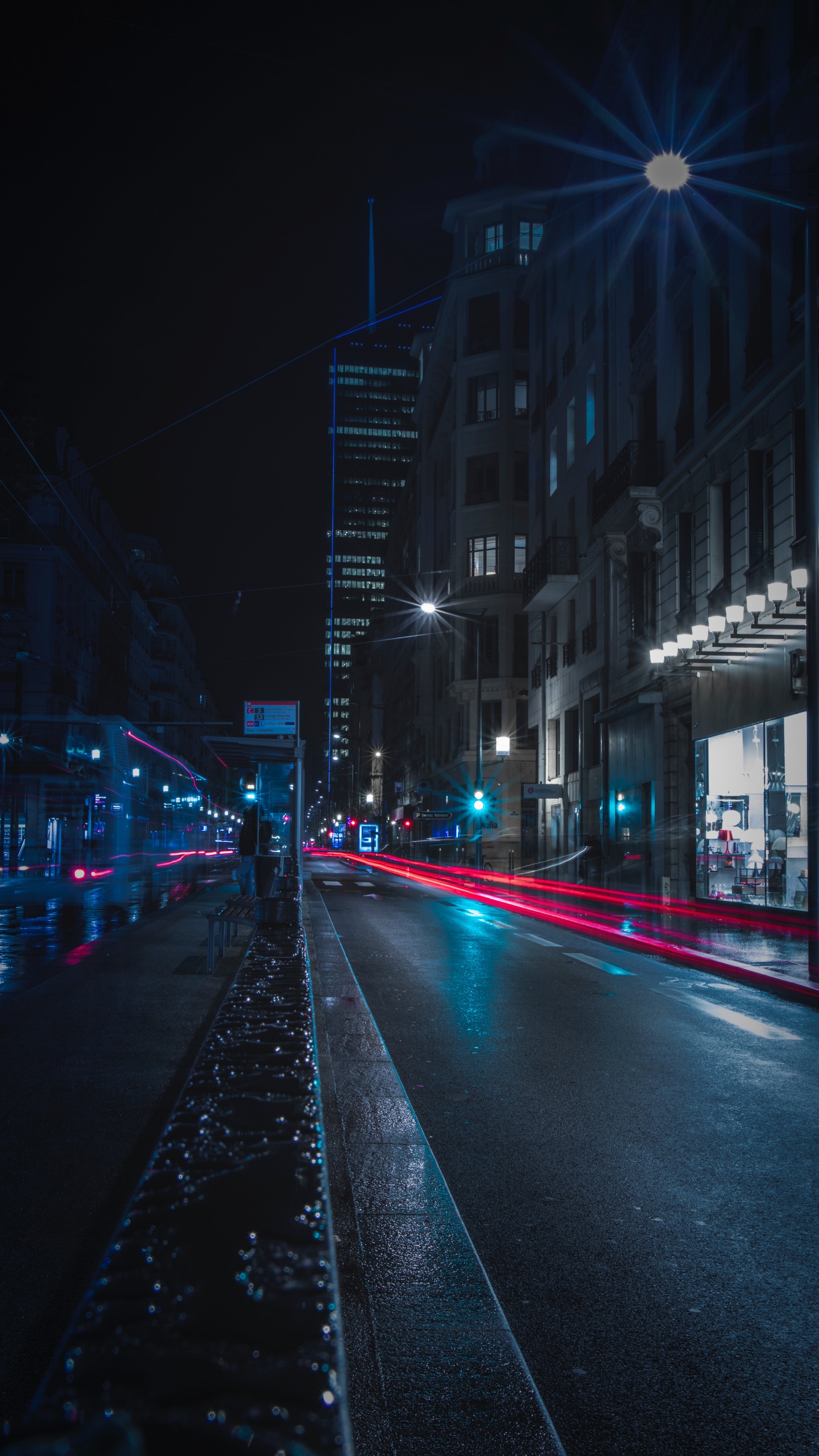 Voitures Sur la Route Entre Les Bâtiments Pendant la Nuit. Wallpaper in 1440x2560 Resolution