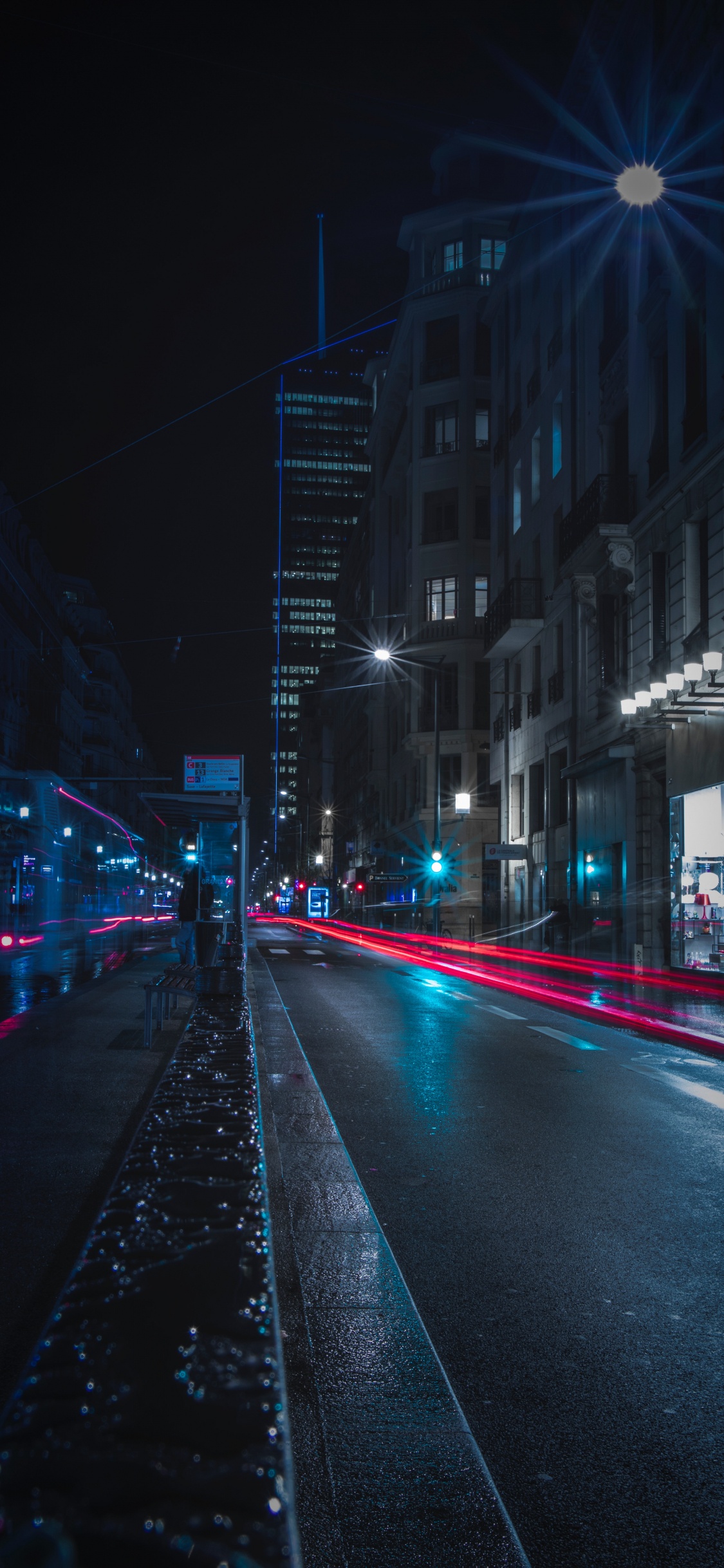 Cars on Road Between Buildings During Night Time. Wallpaper in 1125x2436 Resolution