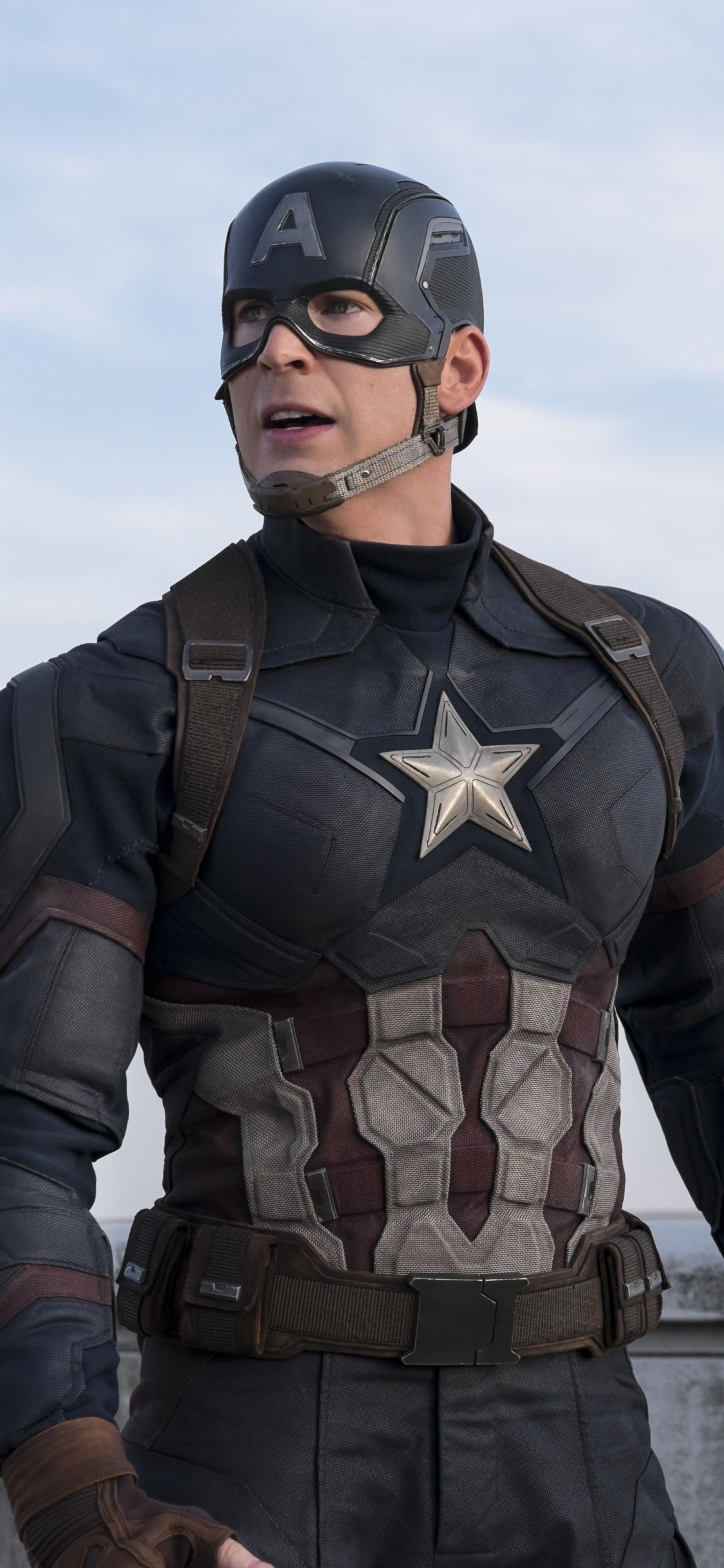 L'homme en Costume de Camouflage Noir et Marron Debout Sur le Quai Pendant la Journée. Wallpaper in 1125x2436 Resolution