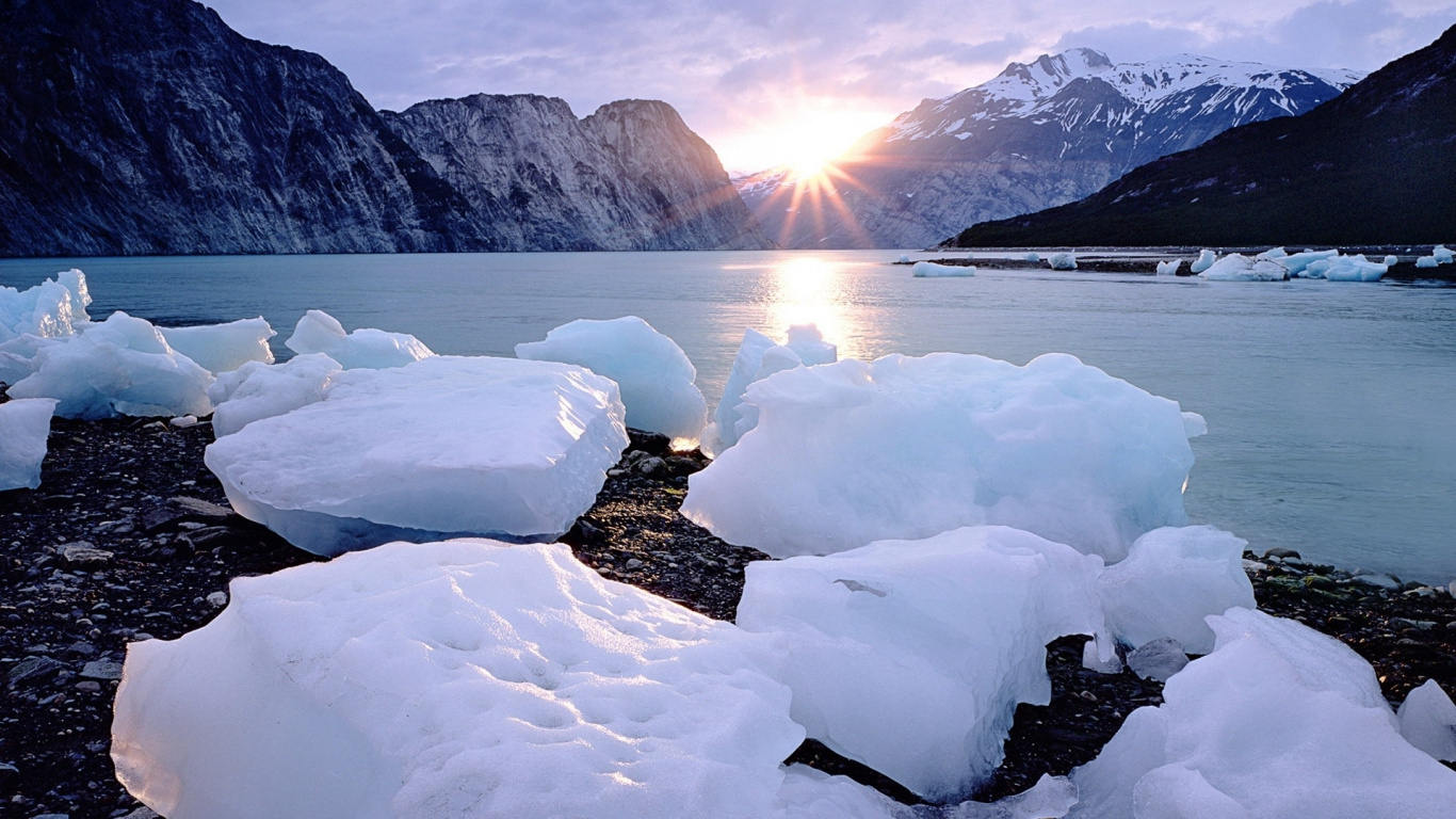 Snow Covered Rocks Near Body of Water During Daytime. Wallpaper in 1366x768 Resolution