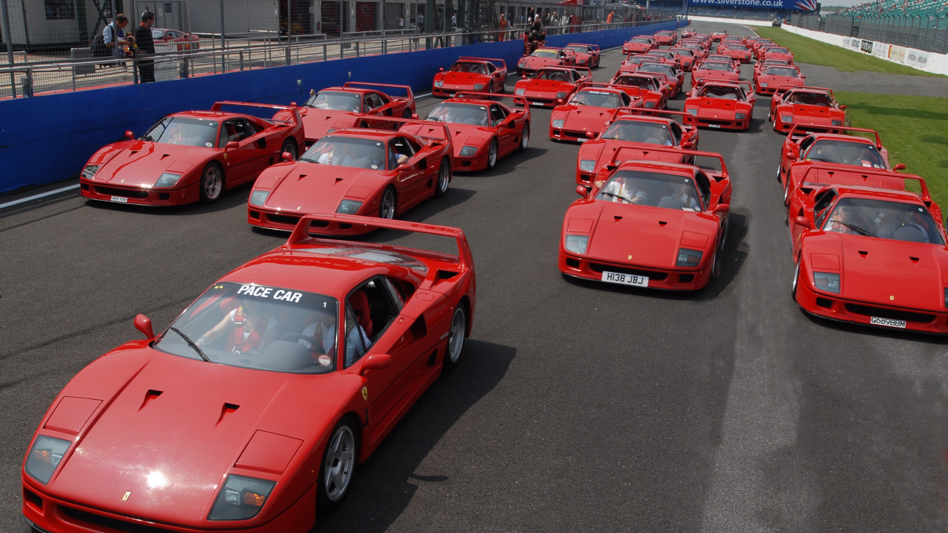 Voiture de Sport Ferrari Rouge Garée Sur un Parking Pendant la Journée. Wallpaper in 1366x768 Resolution