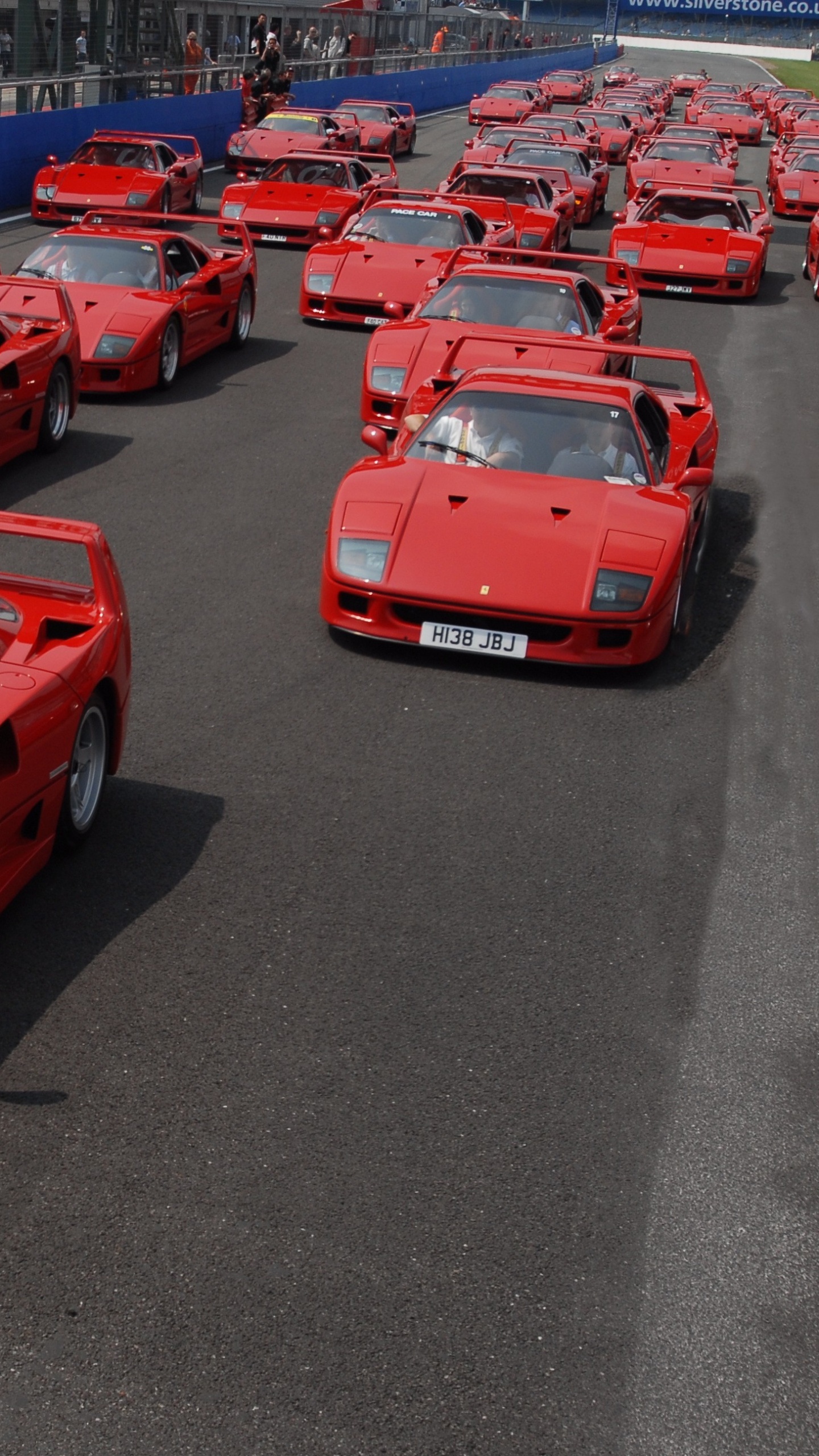 Voiture de Sport Ferrari Rouge Garée Sur un Parking Pendant la Journée. Wallpaper in 1440x2560 Resolution