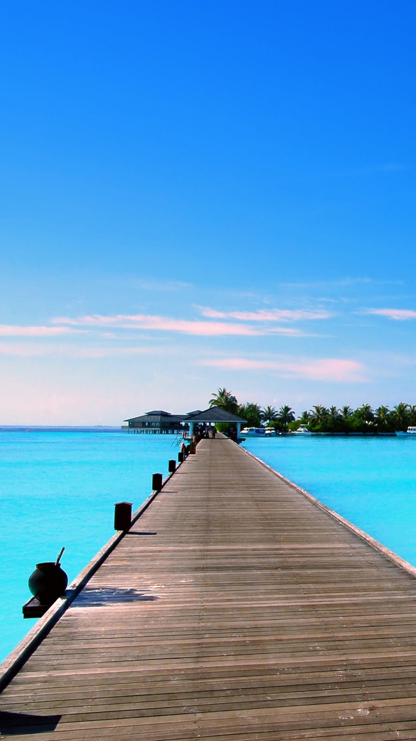 Brown Wooden Dock on Blue Sea Under Blue Sky During Daytime. Wallpaper in 1440x2560 Resolution