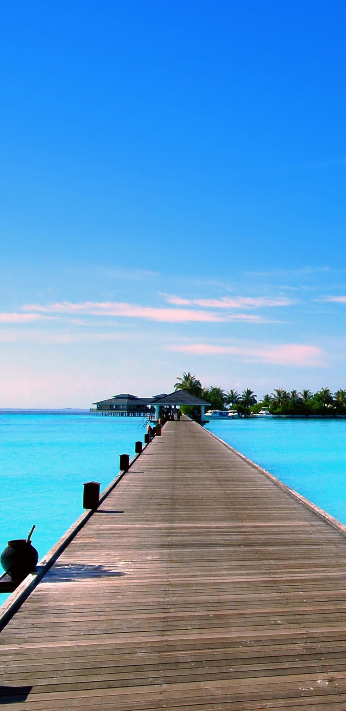 Brown Wooden Dock on Blue Sea Under Blue Sky During Daytime. Wallpaper in 1440x2960 Resolution