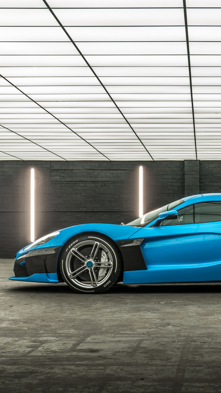 Blauer Porsche 911 Vor Grauer Wand Geparkt. Wallpaper in 750x1334 Resolution