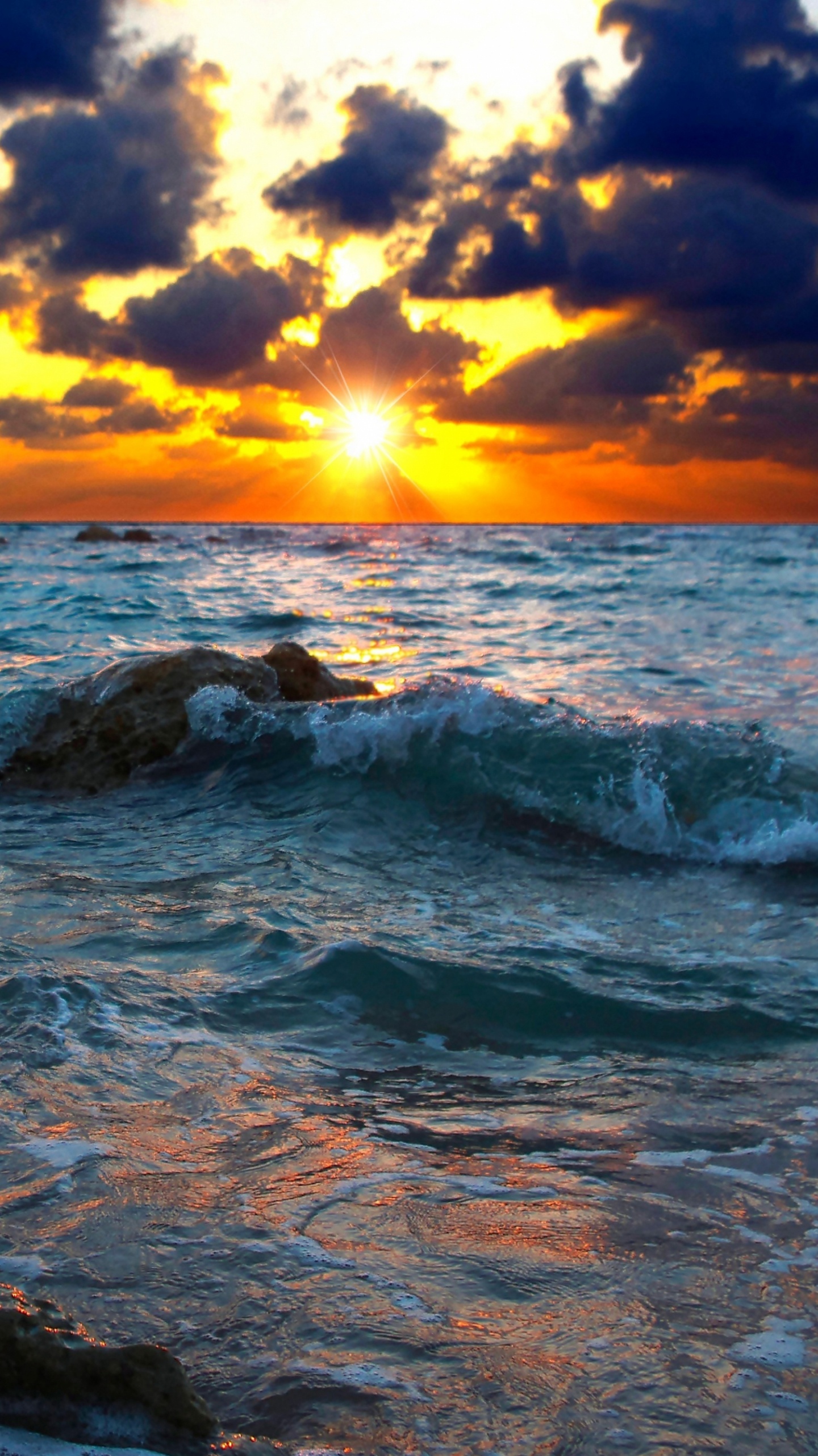 Rocky Shore Under Cloudy Sky During Sunset. Wallpaper in 1440x2560 Resolution