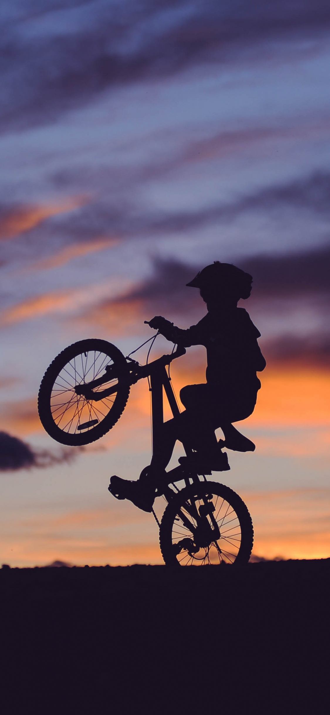 Silhouette Des Mannes, Der Während Des Sonnenuntergangs Fahrrad Fährt. Wallpaper in 1125x2436 Resolution