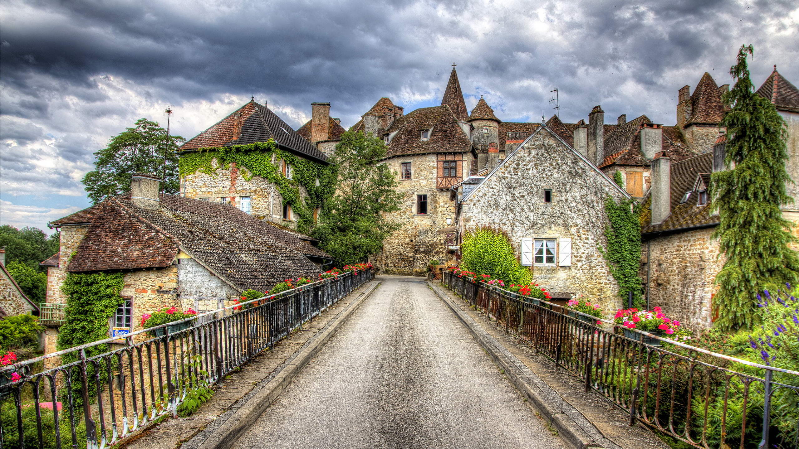 Route en Béton Gris Entre Les Maisons Sous un Ciel Nuageux Blanc Pendant la Journée. Wallpaper in 2560x1440 Resolution