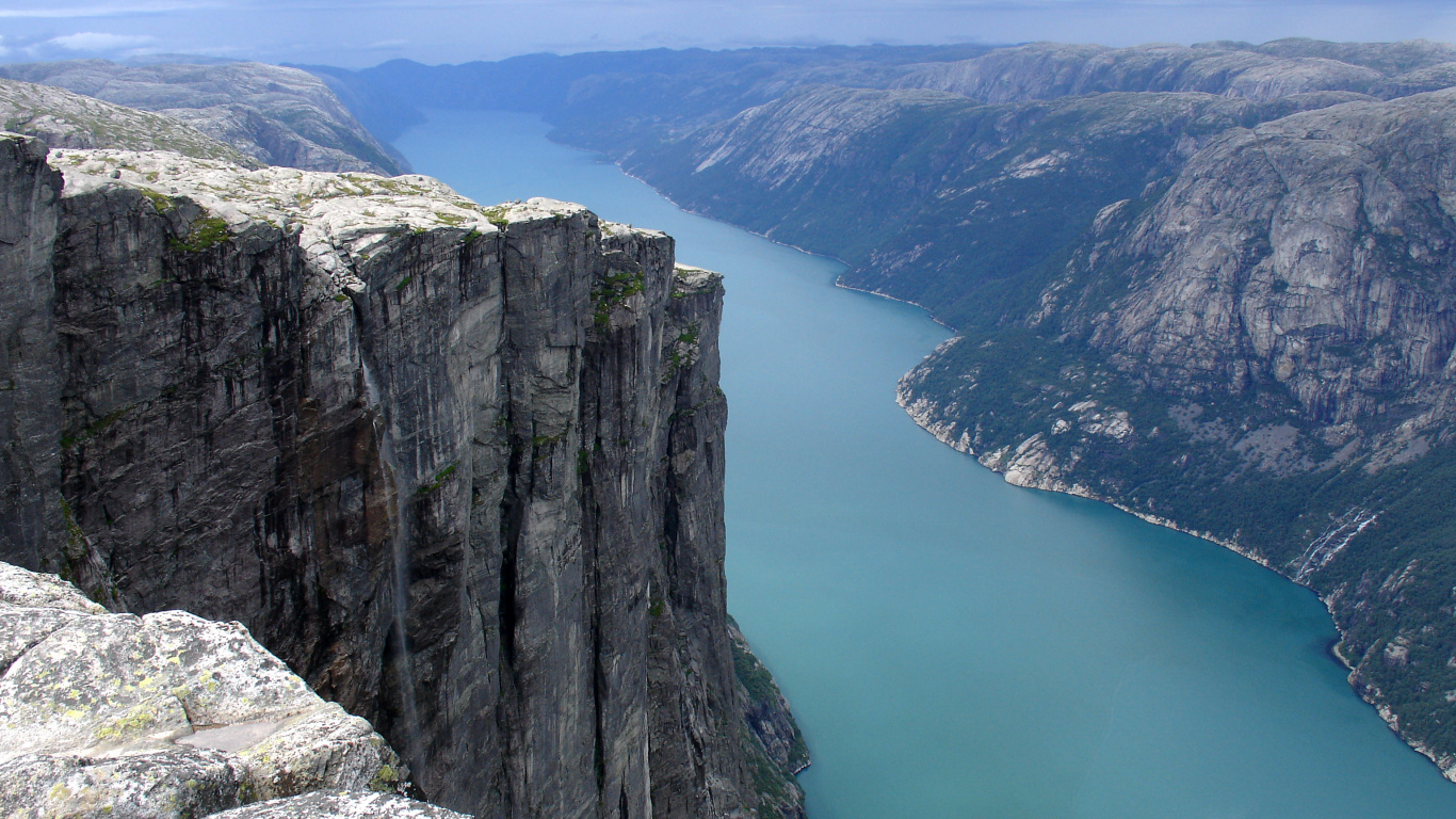 Grauer Felsiger Berg Neben Dem Fluss Tagsüber River. Wallpaper in 1366x768 Resolution