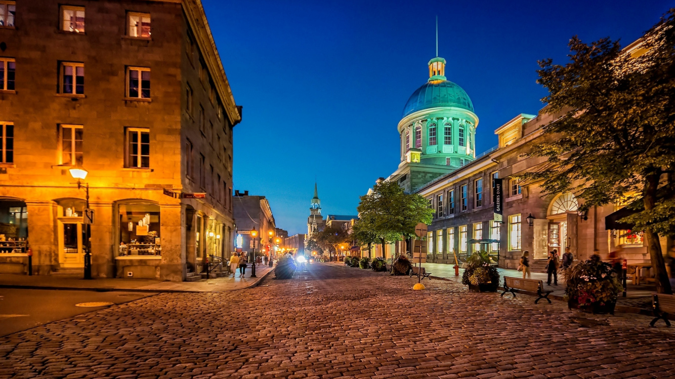 Personnes Marchant Dans la Rue Près D'un Bâtiment en Béton Brun Pendant la Nuit. Wallpaper in 1366x768 Resolution