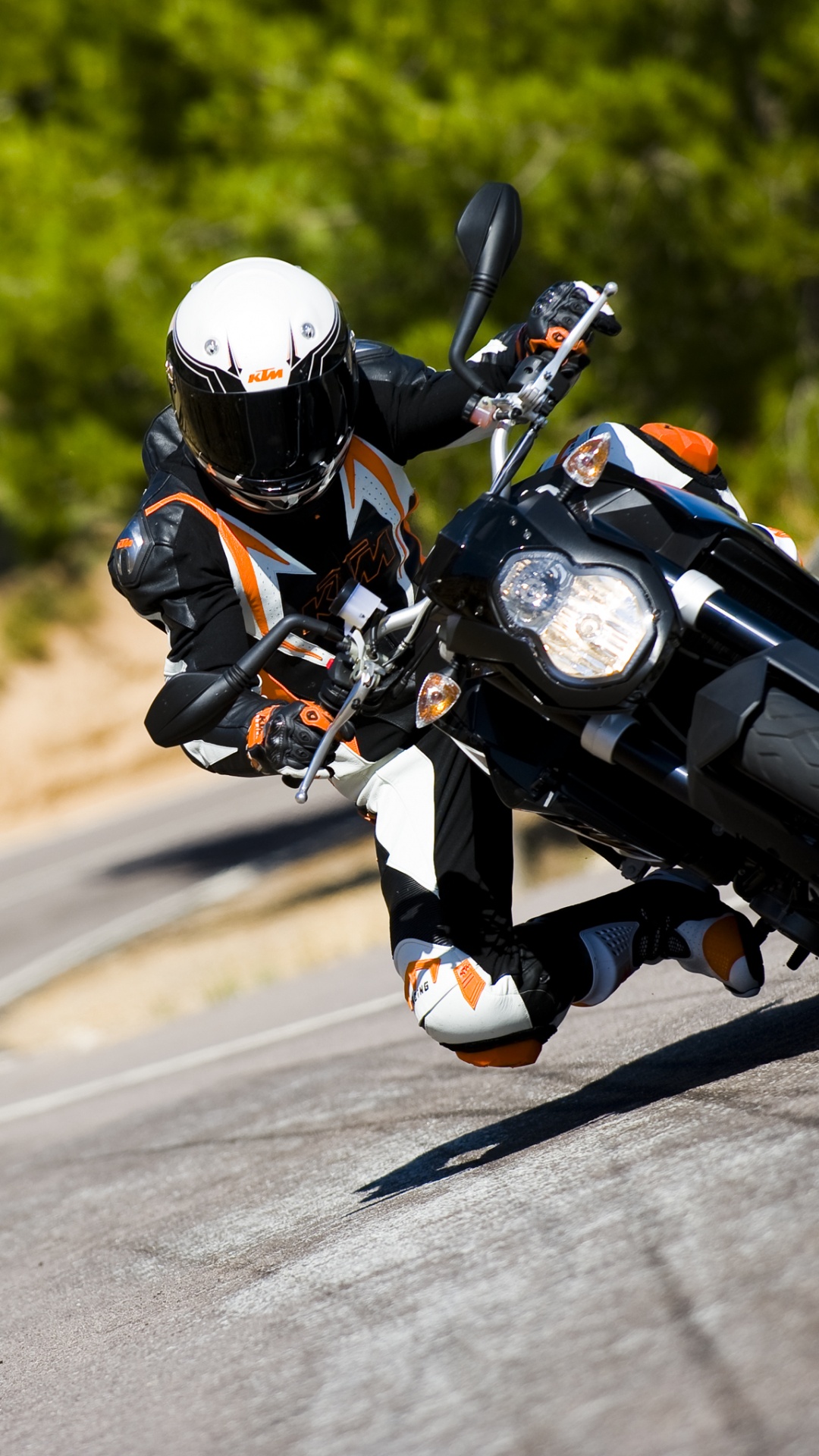 Man in Black and White Motorcycle Suit Riding Motorcycle on Road During Daytime. Wallpaper in 1080x1920 Resolution