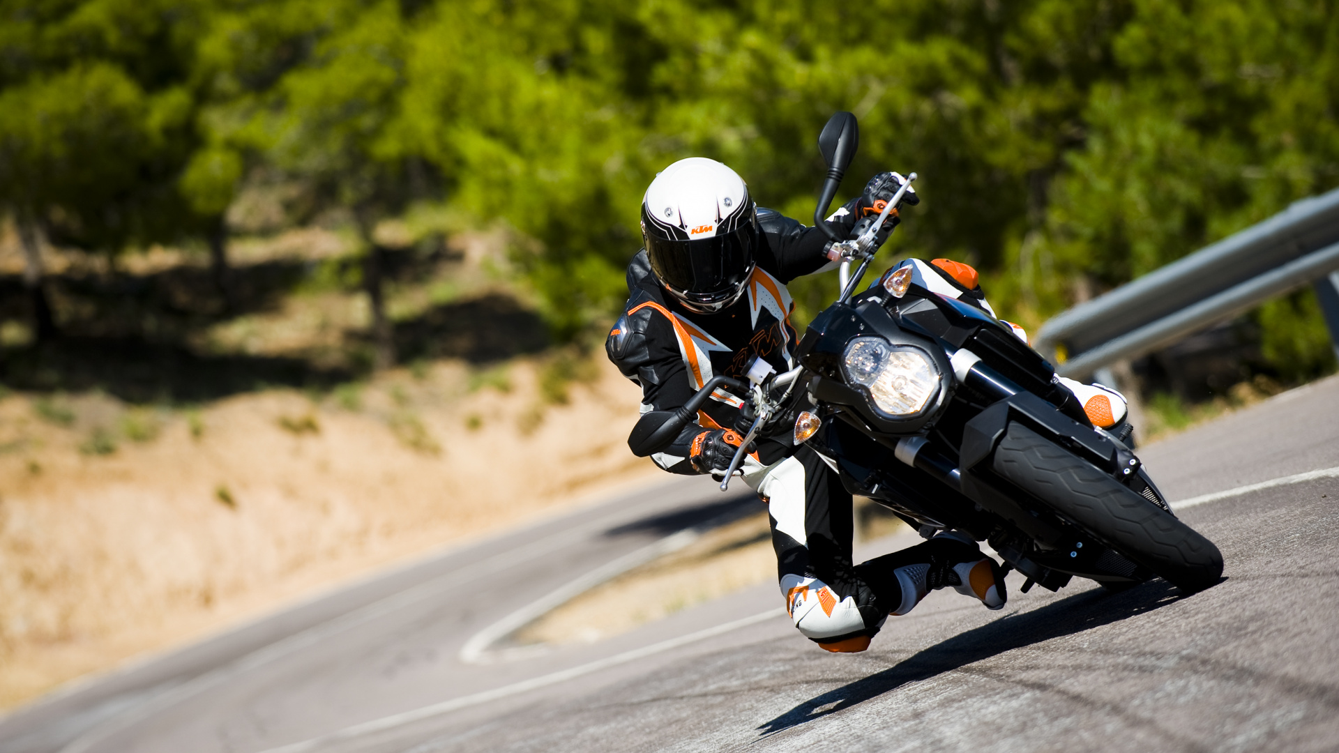 Homme en Costume de Moto Noir et Blanc Équitation Moto Sur Route Pendant la Journée. Wallpaper in 1920x1080 Resolution