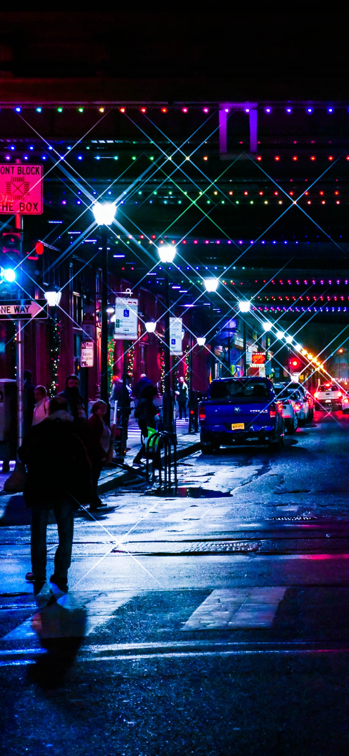 Leute, Die Nachts Auf Der Straße Gehen. Wallpaper in 1125x2436 Resolution