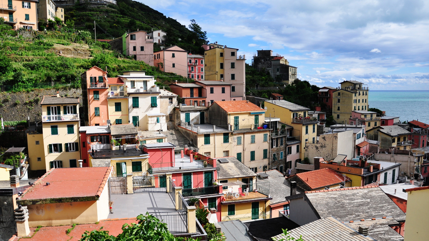Brown and White Concrete Houses Near Green Mountain Under Blue Sky During Daytime. Wallpaper in 1366x768 Resolution
