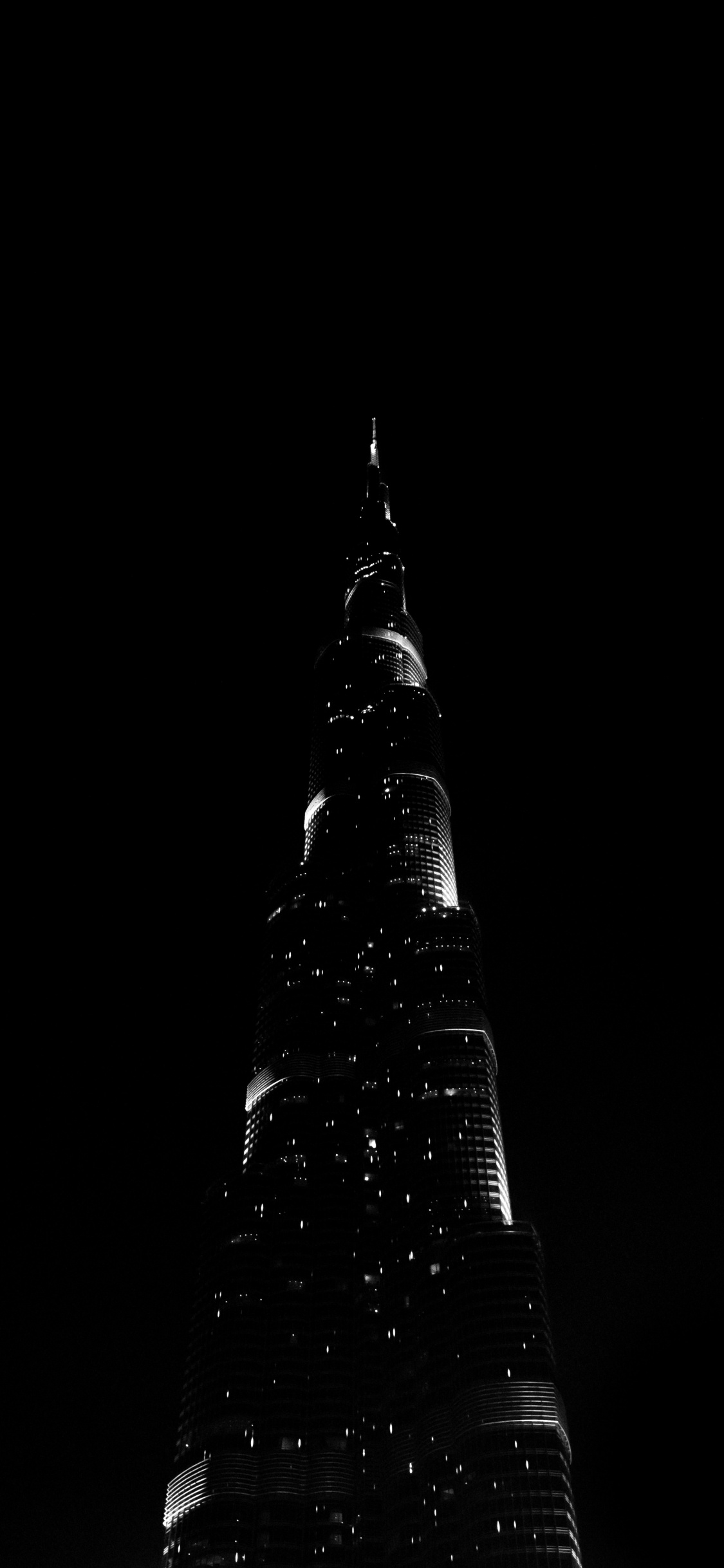 Schwarzer Turm Mit Lichtern Während Der Nacht. Wallpaper in 1125x2436 Resolution