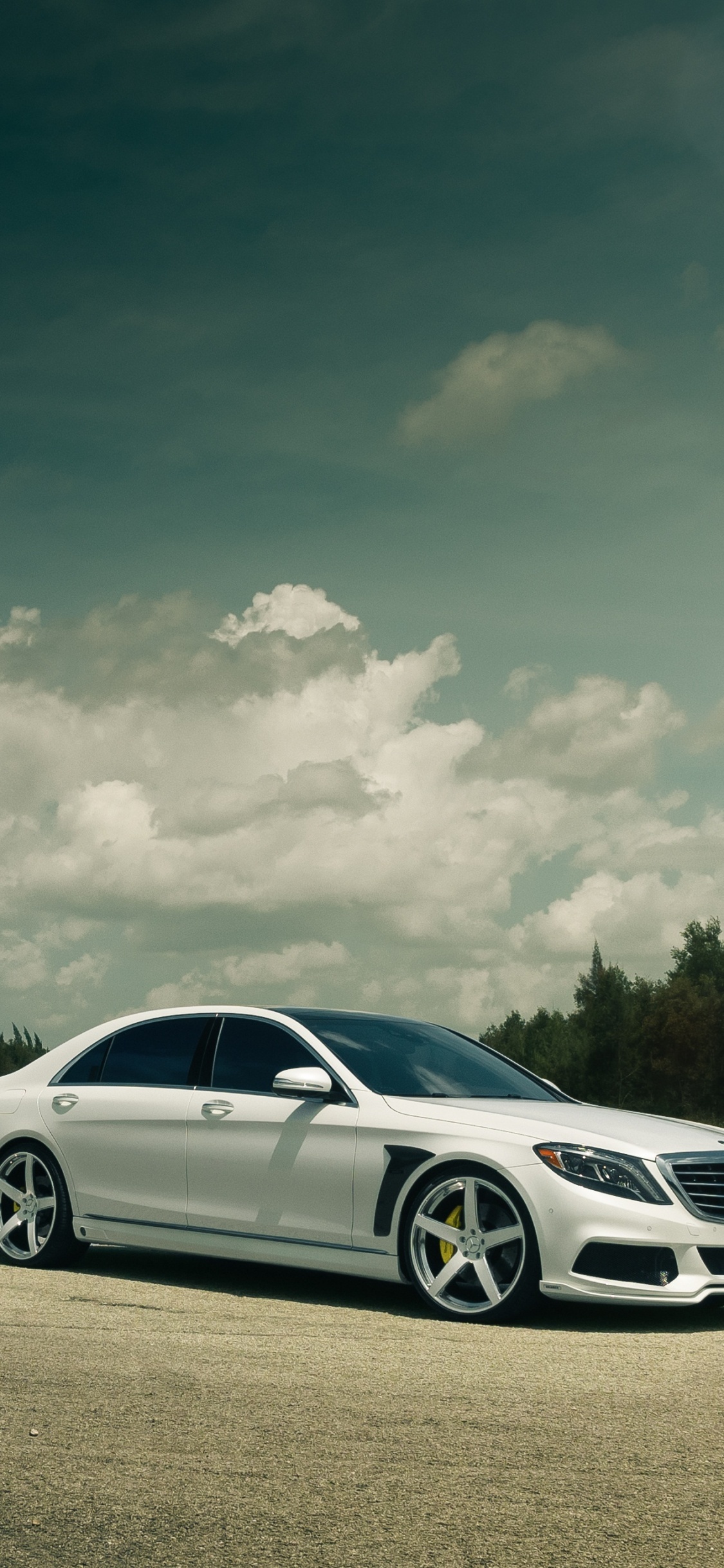 White Sedan on Gray Asphalt Road Under White Clouds and Blue Sky During Daytime. Wallpaper in 1125x2436 Resolution
