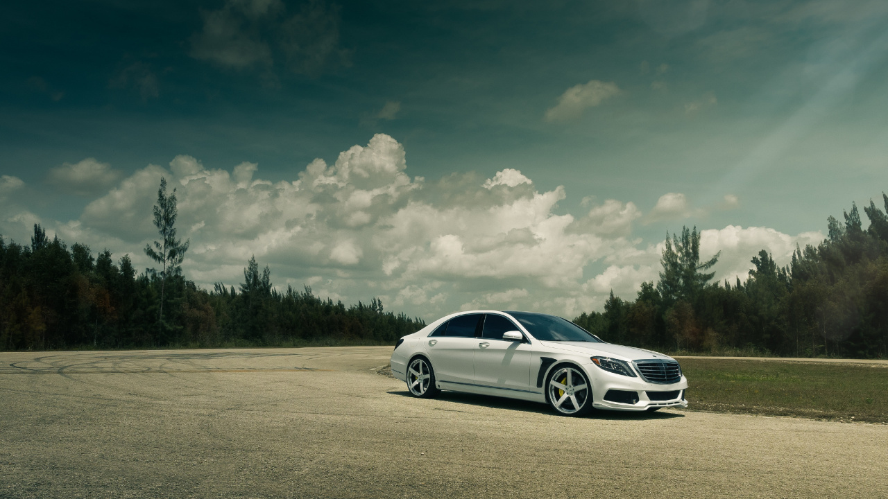 Weiße Limousine Auf Grauer Asphaltstraße Unter Weißen Wolken Und Blauem Himmel Tagsüber. Wallpaper in 1280x720 Resolution
