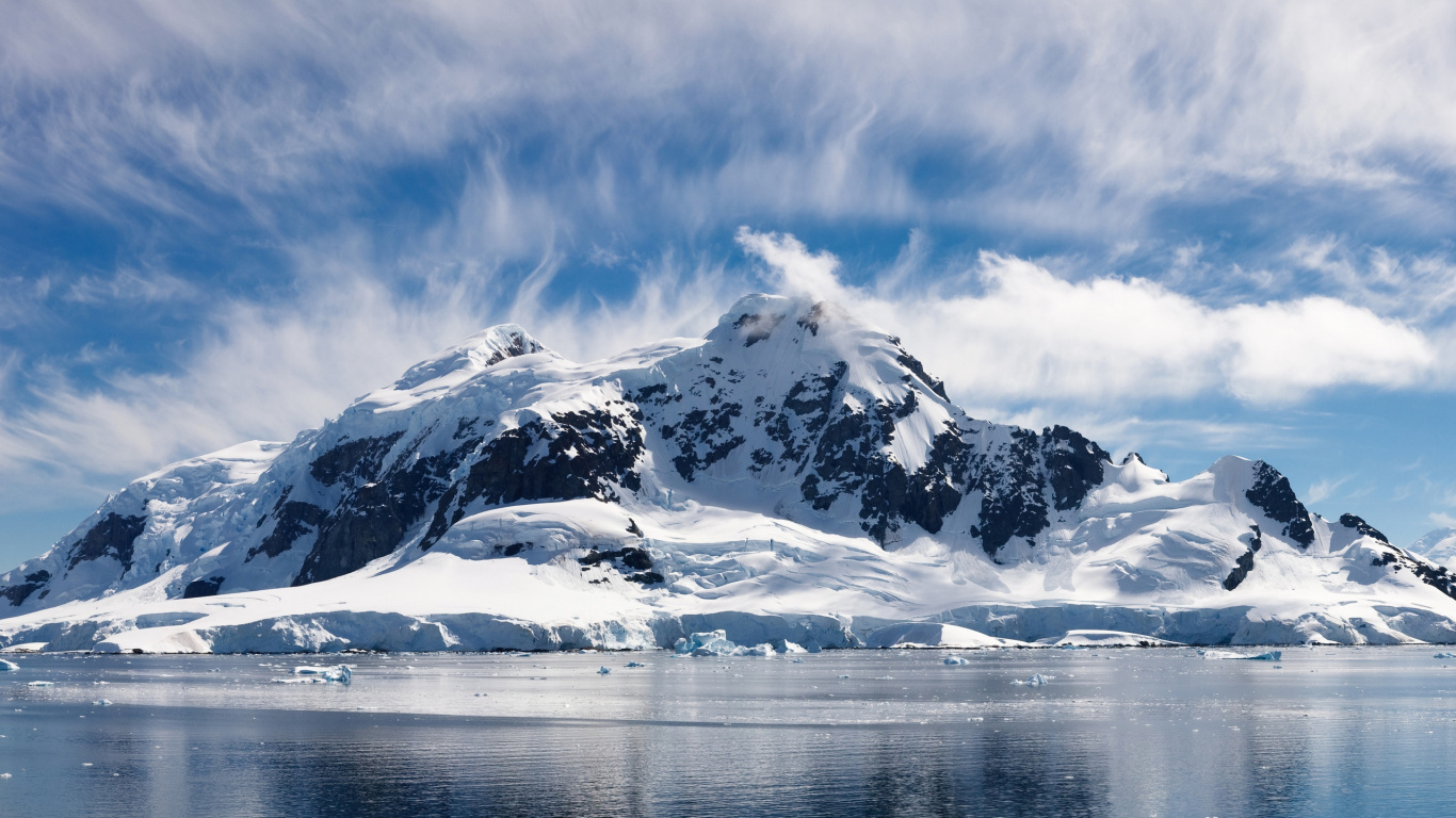 Snow Covered Mountain Near Body of Water During Daytime. Wallpaper in 1366x768 Resolution