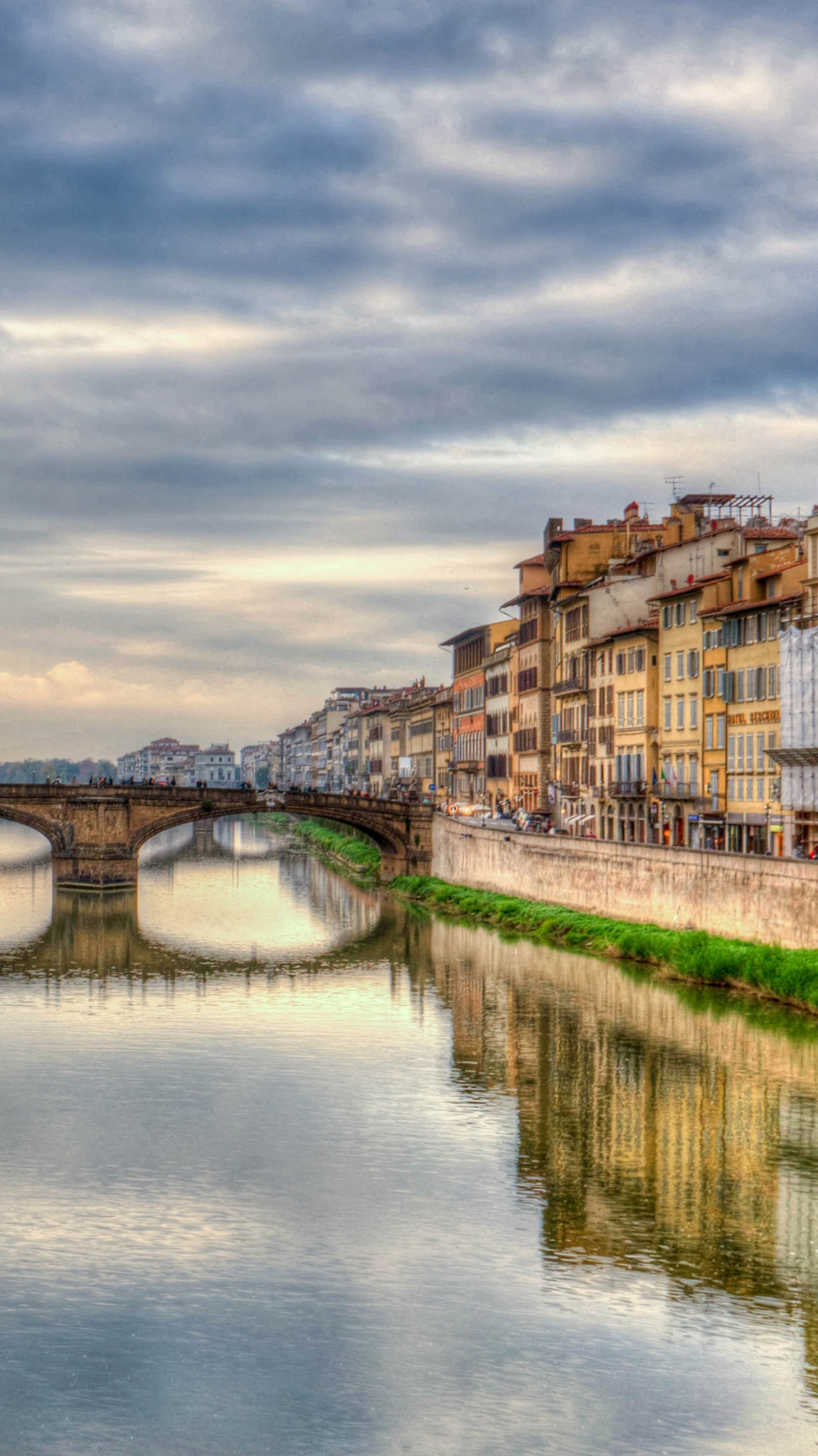 Brown Concrete Building Near River Under Cloudy Sky During Daytime. Wallpaper in 1440x2560 Resolution