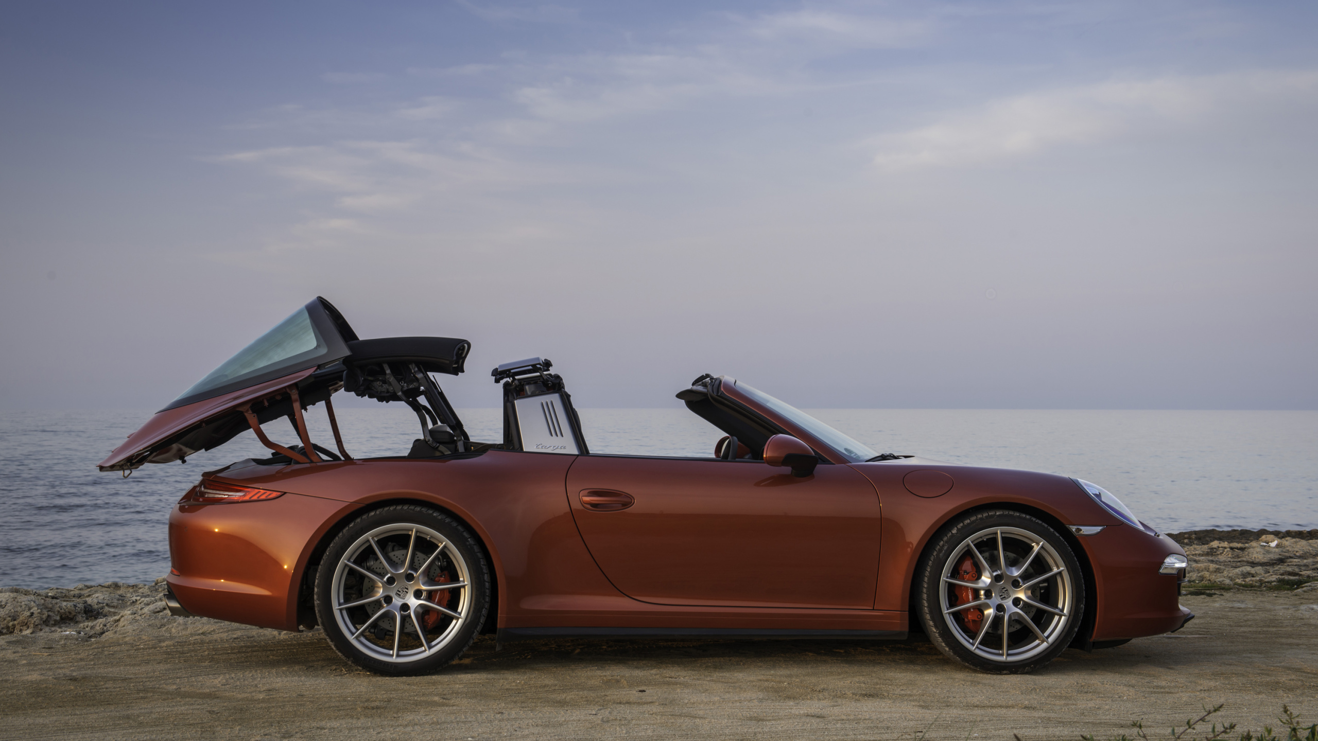 Brown Convertible Coupe on Green Grass Field Under White Clouds During Daytime. Wallpaper in 2560x1440 Resolution