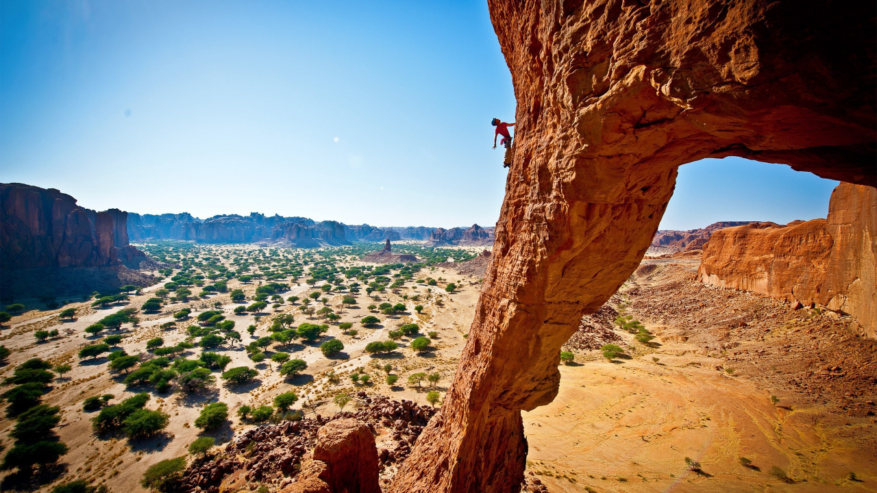 Person Standing on Brown Rock Formation During Daytime. Wallpaper in 1280x720 Resolution