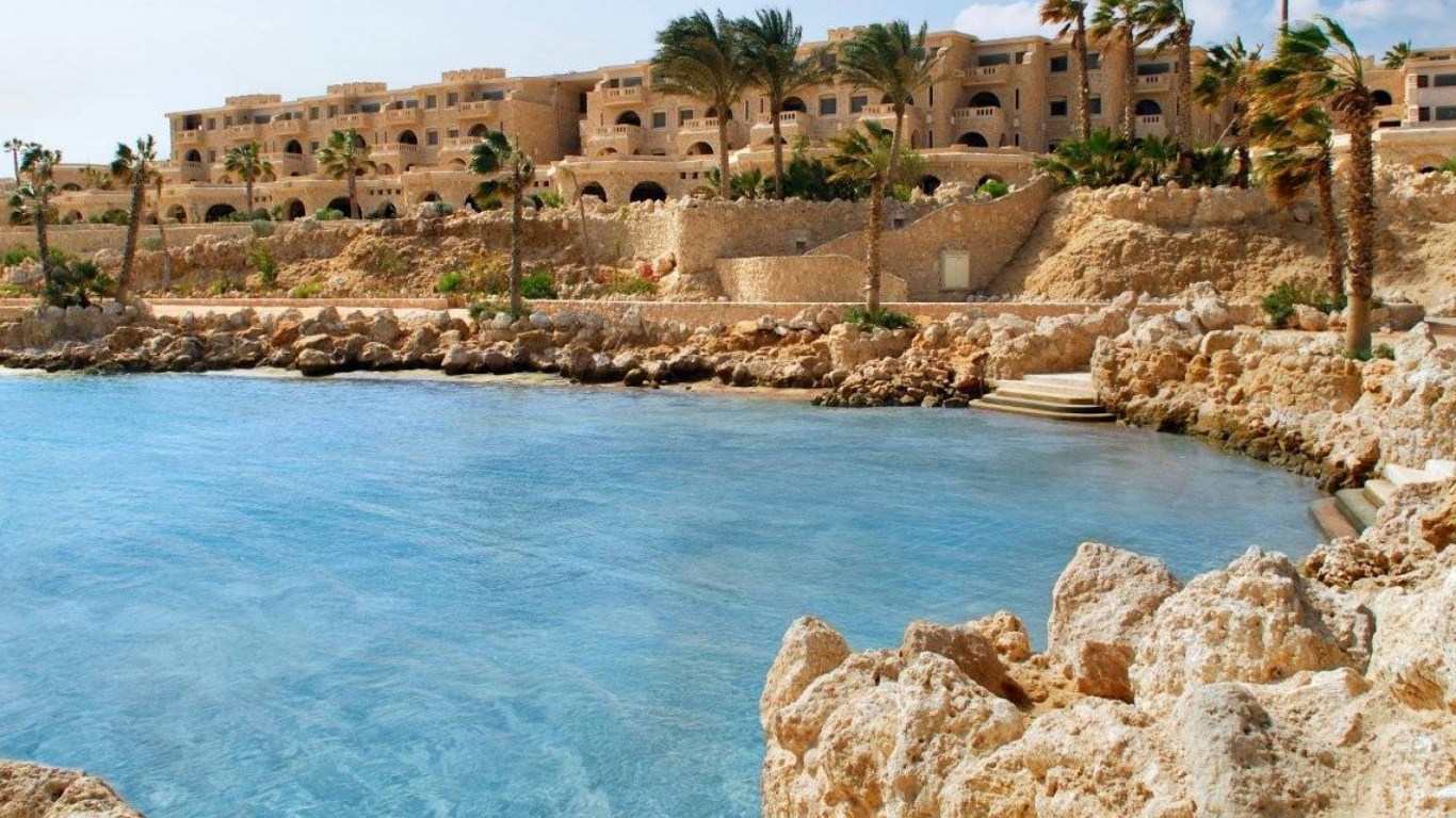 Bâtiment en Béton Brun Près D'un Plan D'eau Pendant la Journée. Wallpaper in 1366x768 Resolution