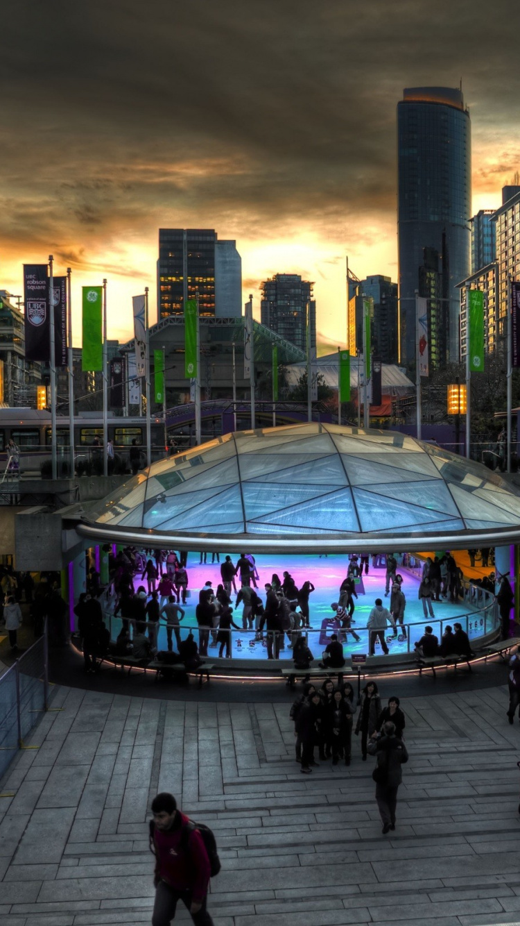 Personnes Marchant Sur le Parc Près Des Immeubles de Grande Hauteur Pendant la Nuit. Wallpaper in 750x1334 Resolution