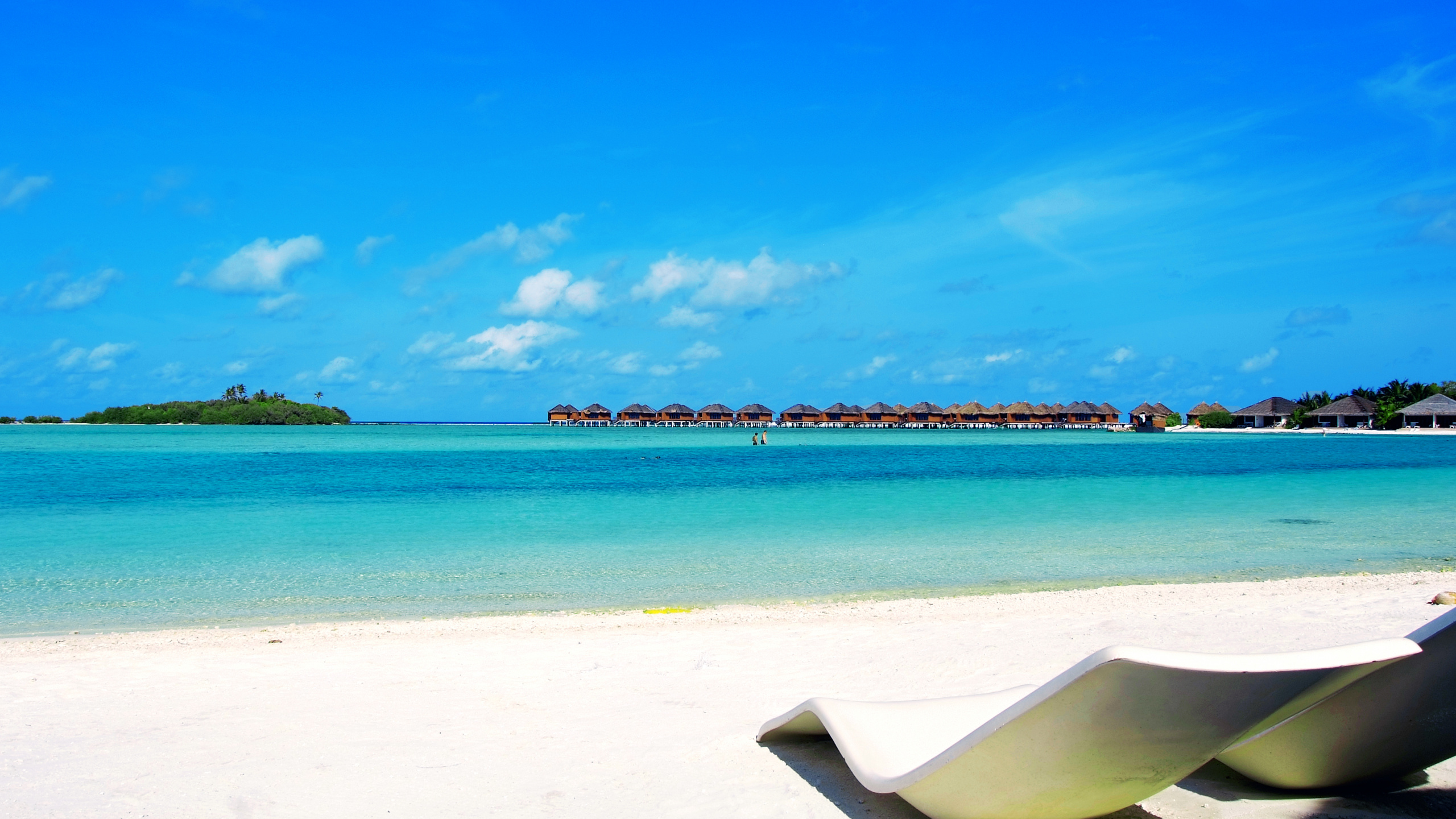 Chaise de Plage Blanche et Bleue Sur du Sable Blanc Près D'un Plan D'eau Pendant la Journée. Wallpaper in 2560x1440 Resolution