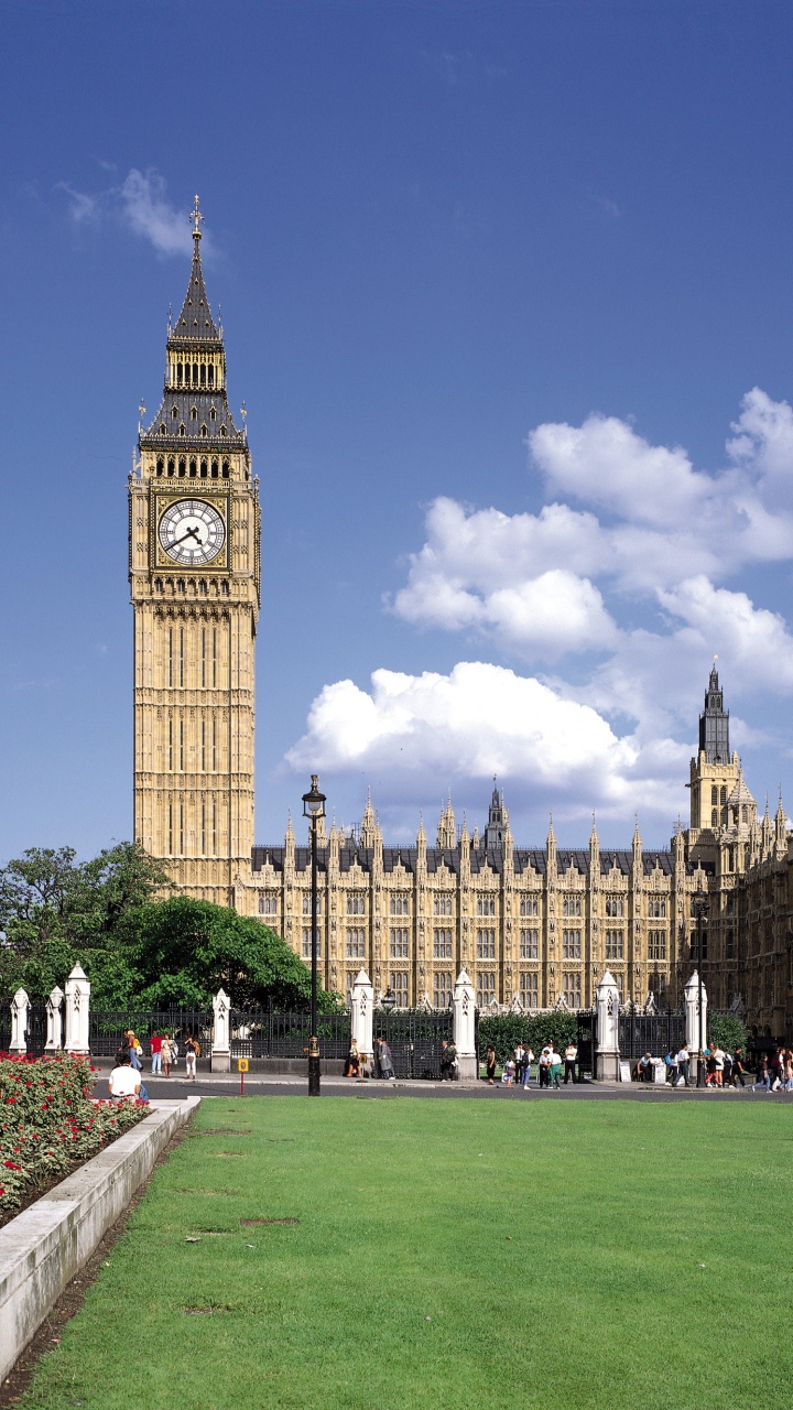 Menschen, Die Tagsüber Auf Einer Grünen Wiese in Der Nähe Eines Braunen Betongebäudes Gehen. Wallpaper in 720x1280 Resolution