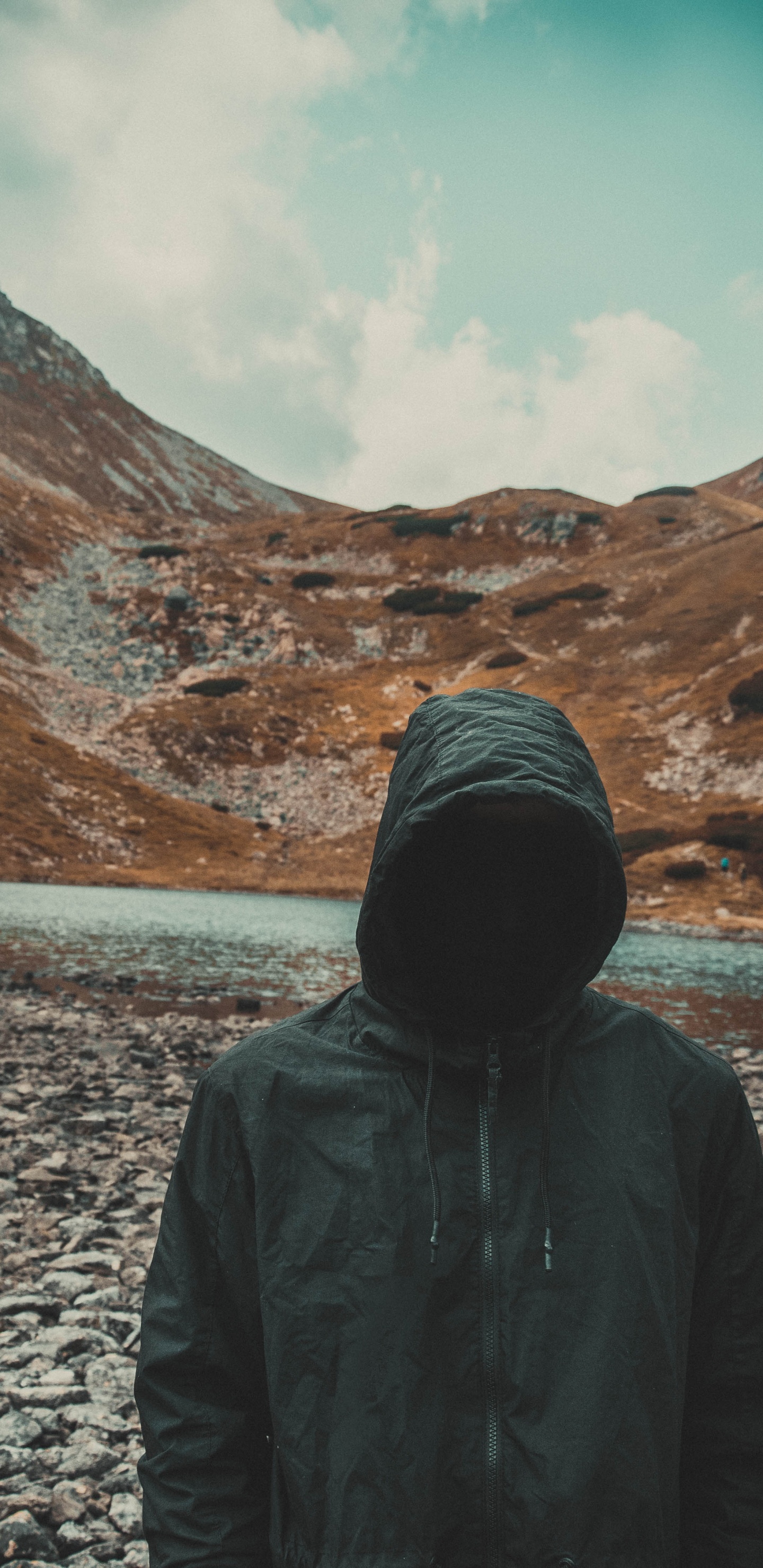 Personne en Sweat à Capuche Noir Debout Sur un Sol Rocheux Gris Pendant la Journée. Wallpaper in 1440x2960 Resolution