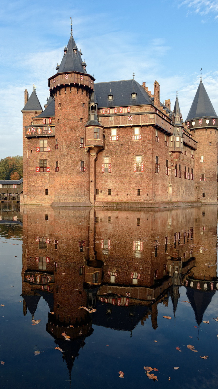 Brown Concrete Building Near Body of Water During Daytime. Wallpaper in 750x1334 Resolution
