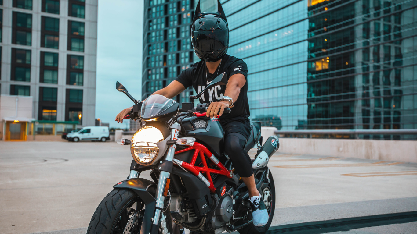 Mann Mit Schwarzem Helm, Der Auf Einem Orangefarbenen Und Schwarzen Motorrad Fährt. Wallpaper in 1366x768 Resolution