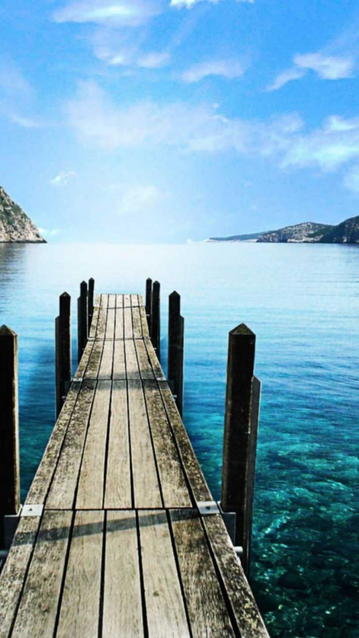 Brown Wooden Dock on Blue Sea Under Blue Sky During Daytime. Wallpaper in 720x1280 Resolution