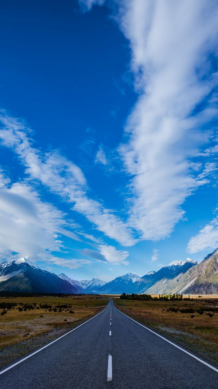 Gray Concrete Road Near Mountain Under Blue Sky During Daytime. Wallpaper in 750x1334 Resolution