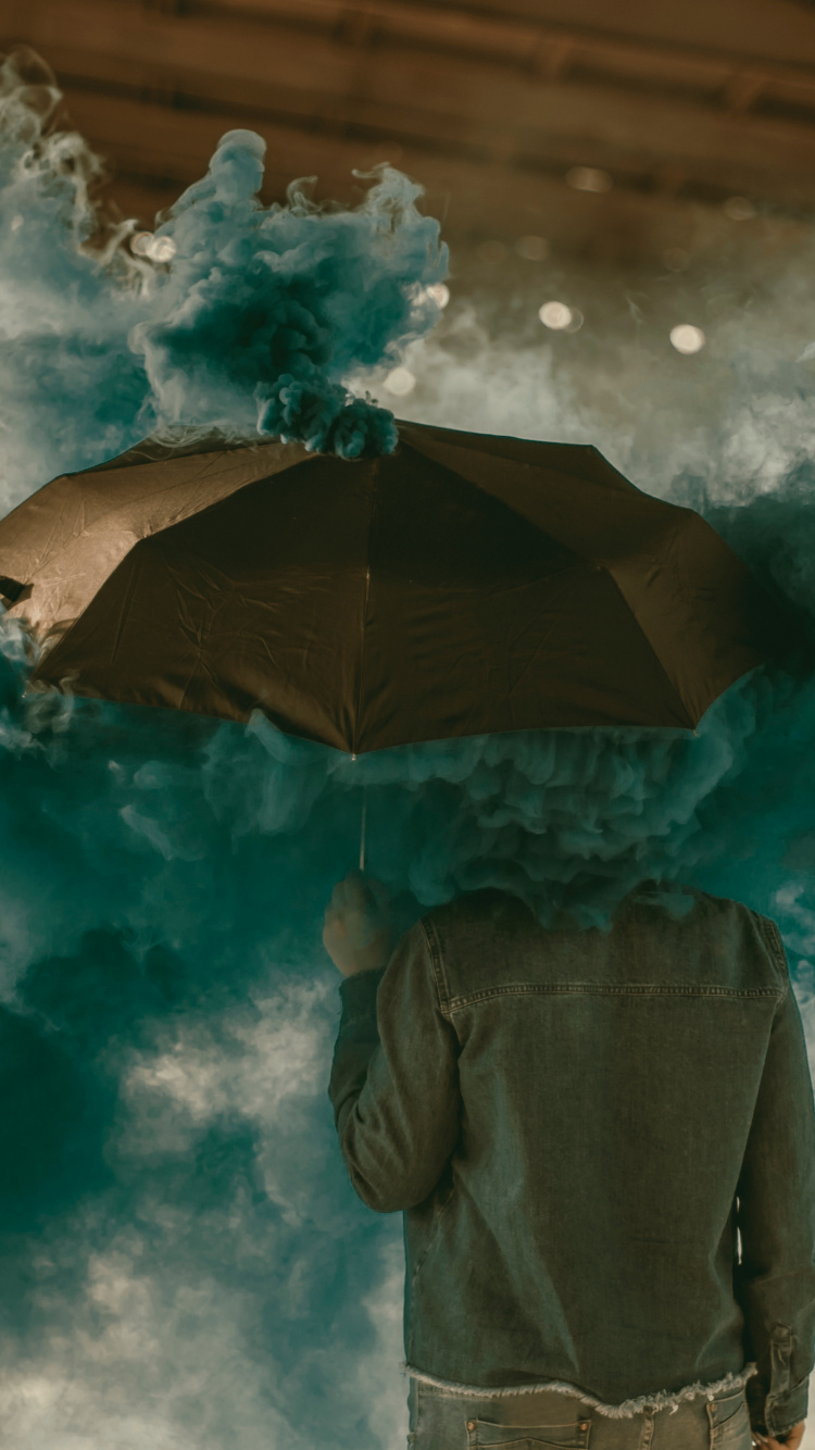 Person in Brauner Jacke Mit Regenschirm Unter Weißen Wolken. Wallpaper in 750x1334 Resolution