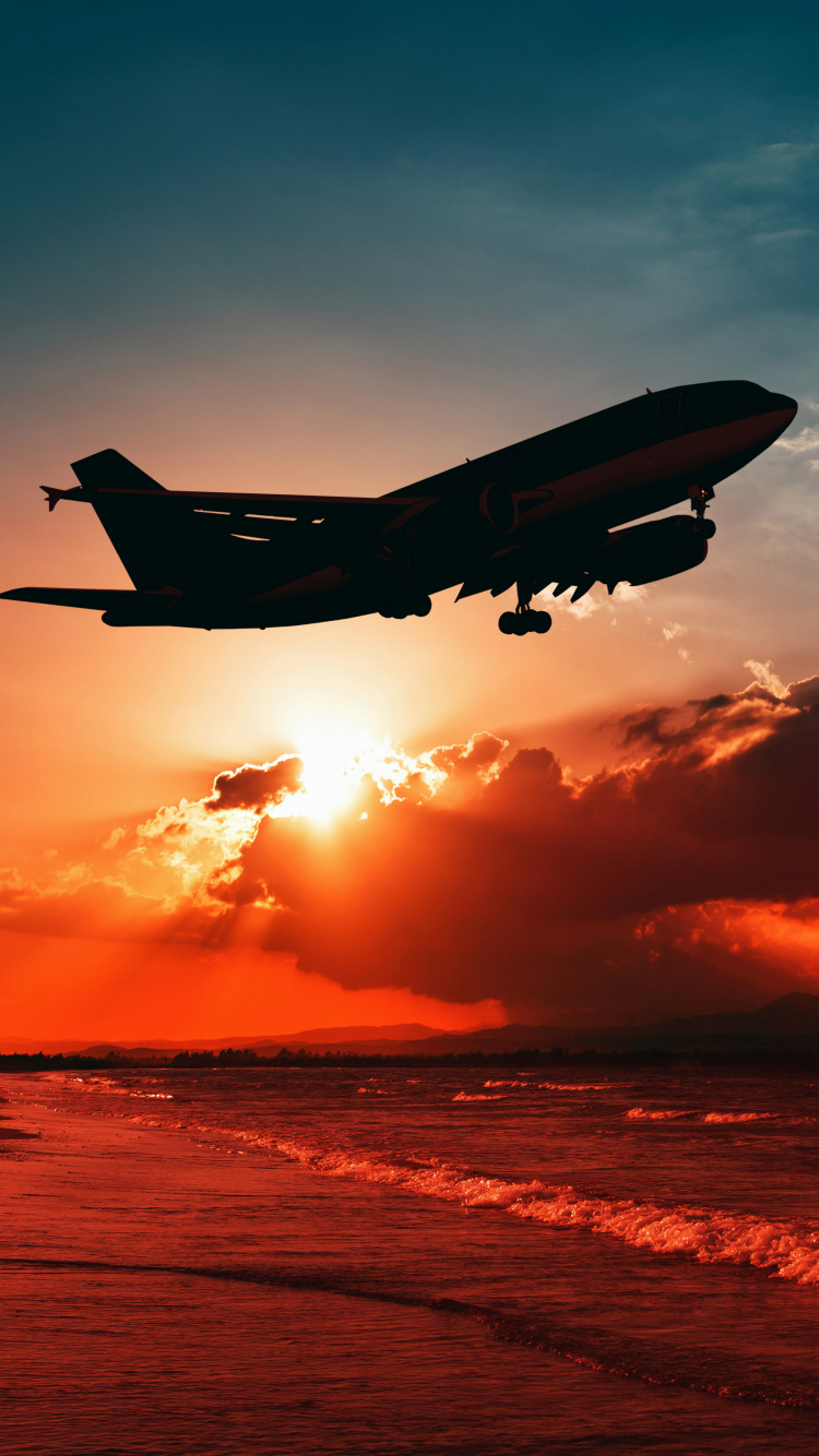 Airplane Flying Over The Clouds During Sunset. Wallpaper in 750x1334 Resolution