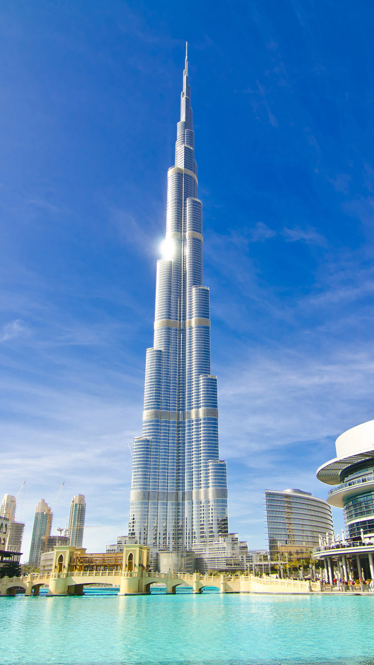White and Blue High Rise Building Near Body of Water During Daytime. Wallpaper in 750x1334 Resolution